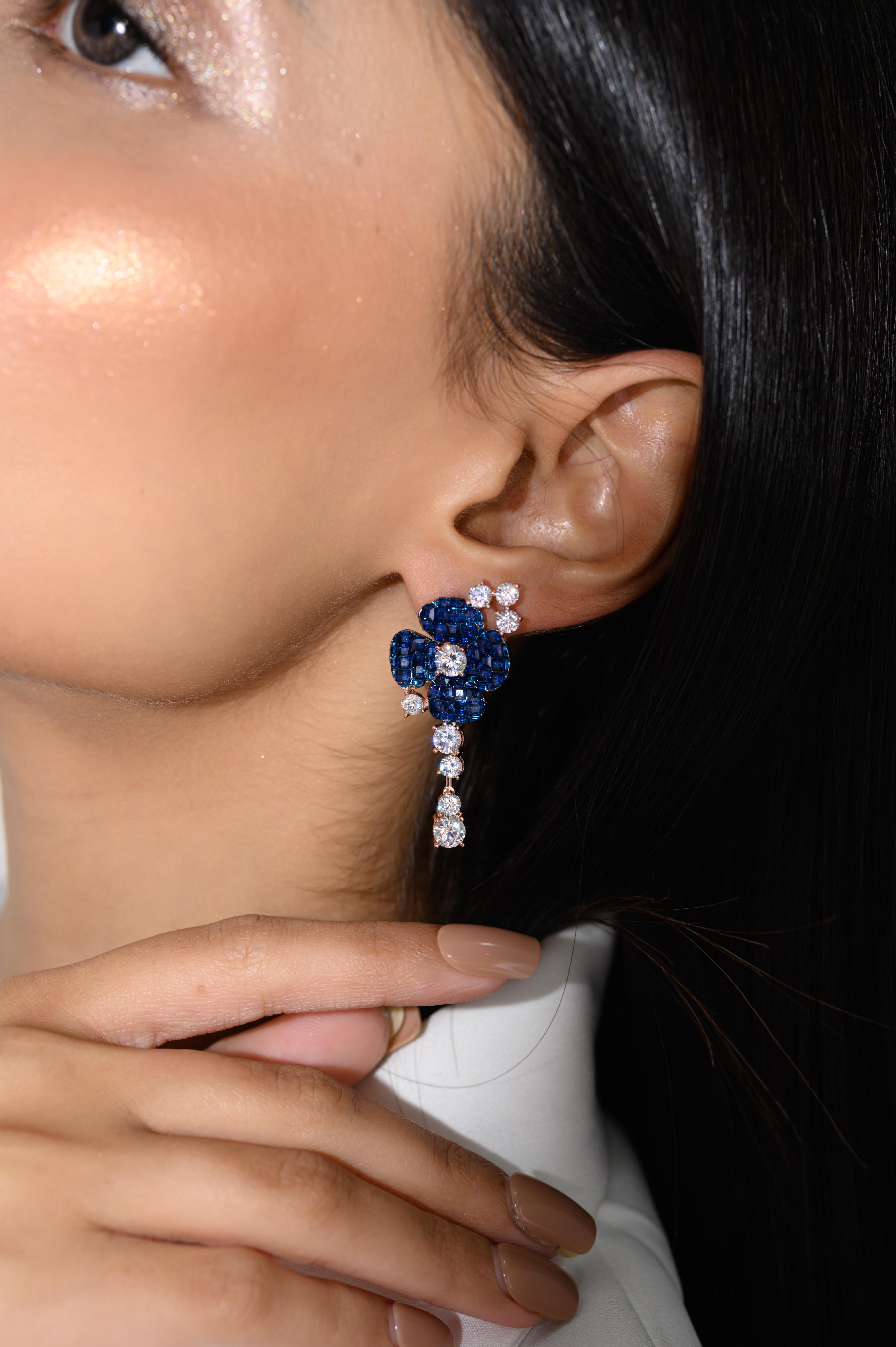 These Rose Gold Blue Diamond Flower Drop Earrings are a striking and elegant accessory that beautifully combine the allure of blue stones with the sophistication of rose gold. The earrings feature a delicate flower design, where each petal is