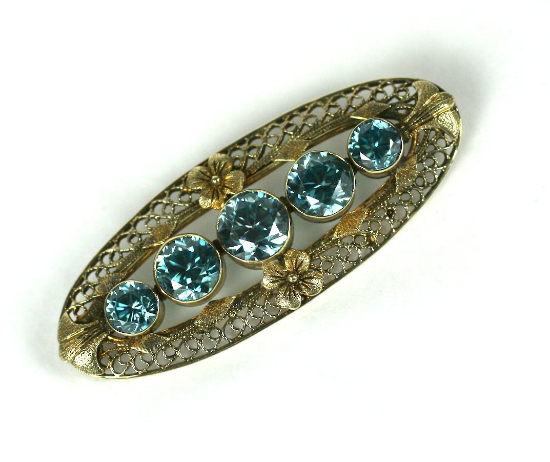 Blue Zircon Deco Brooch from the 1930's in a delicate 14k green gold filigree setting. 
5 large blue zircons, slightly different in size, but of beautiful color and cut. 
There are (2) .65 carats, (2) .85 carats, and (1) center stone at 1.25
