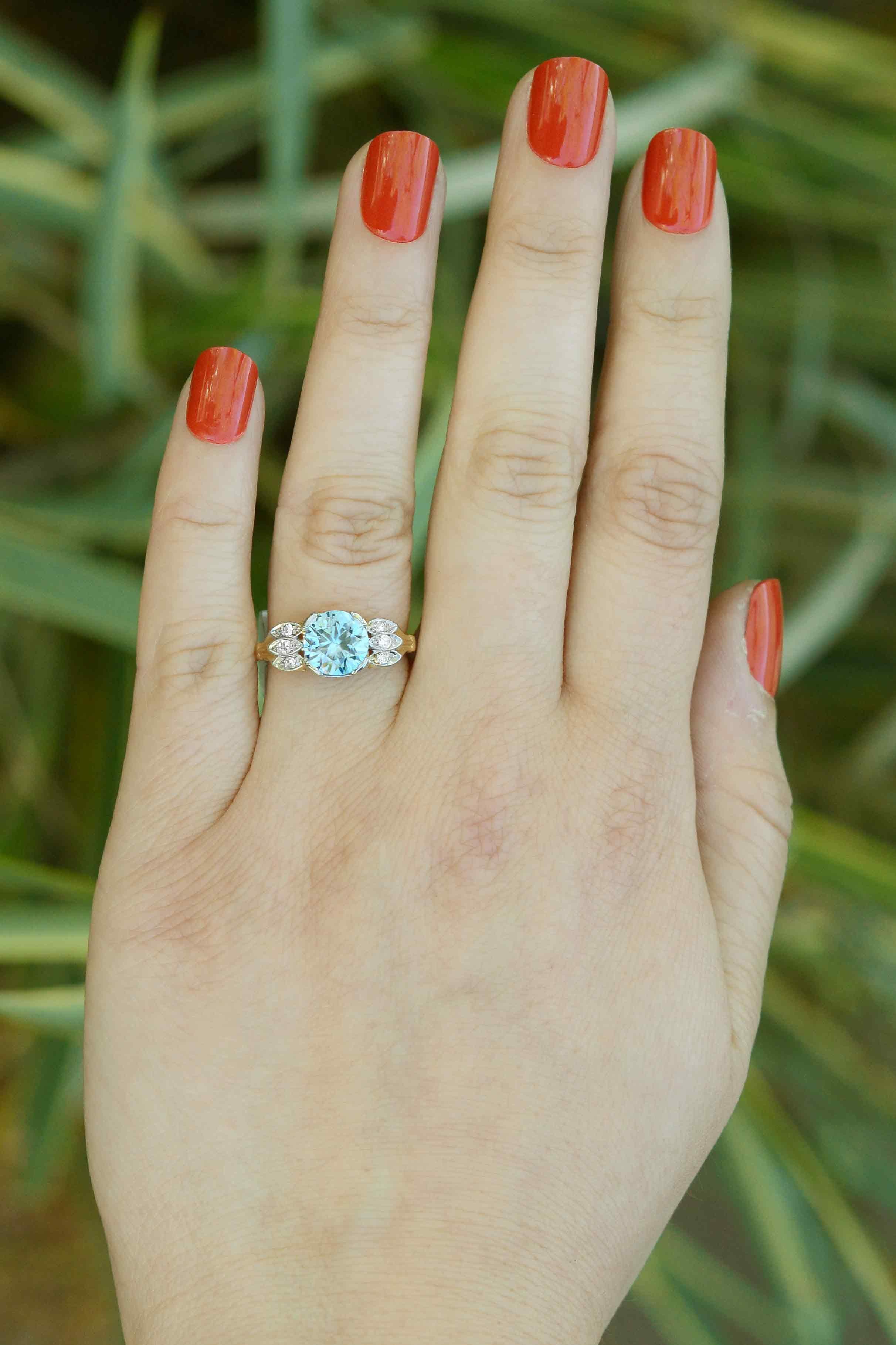 The Shelburne Art Deco blue zircon and diamond engagement ring centers on an electric, neon gem weighing 2.87 carats with diamond-kissed shoulders. With its vintage, 1940s Retro era vibe, this colored gemstone engagement ring will wow you with its
