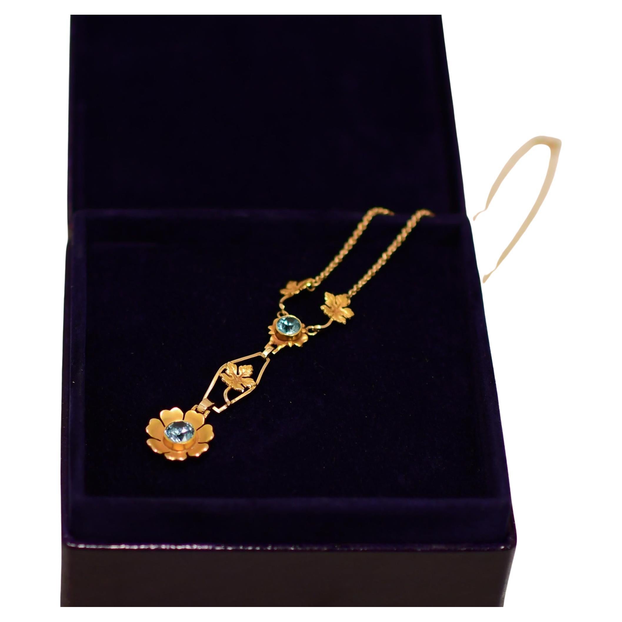 Tauchen Sie ein in die glamouröse Welt des Art déco mit dieser atemberaubenden Halskette. Das Herzstück dieses exquisiten Schmuckstücks ist ein faszinierender blauer Zirkon, der sicher in einer eleganten Lünette gefasst ist. Der leuchtend blaue