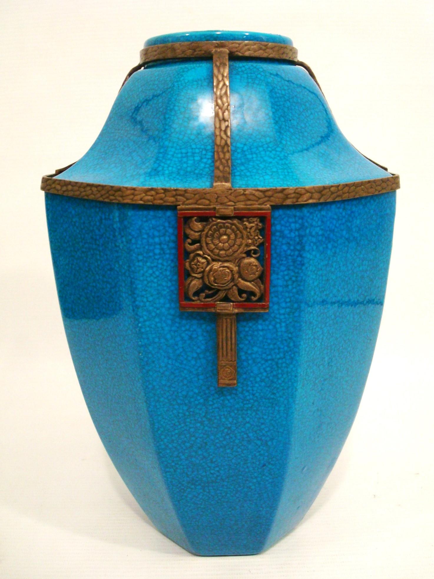 Art Deco Boch La Louviere Brass Mounted Glazed Vase. Belgium 1920´s.

Very Rare  blue Glazed ceramic vase. The vase has a hexagonal shape and is adorned with bronze or brass decorative elements. There is a band around the top and middle of the vase,