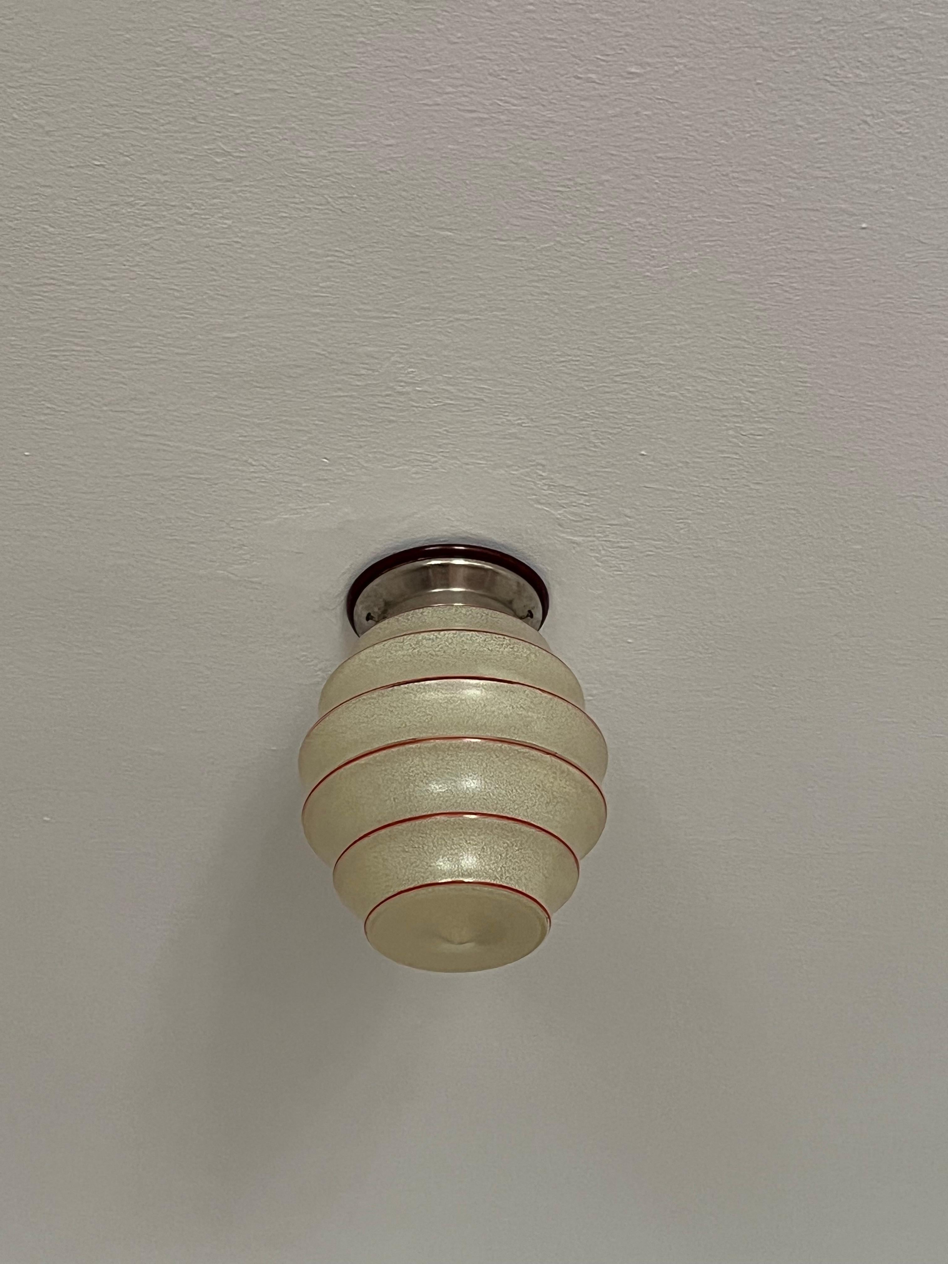 Beautiful Art Deco ceiling fixture in chrome with an interesting beehive shaped striped Art Glass shade. 

Made in 1930s Czechoslovakia. Very rare and unique design in excellent condition.


Dimension:
Height: 27cm (10.6 inch.)
Width: 20cm (7.8