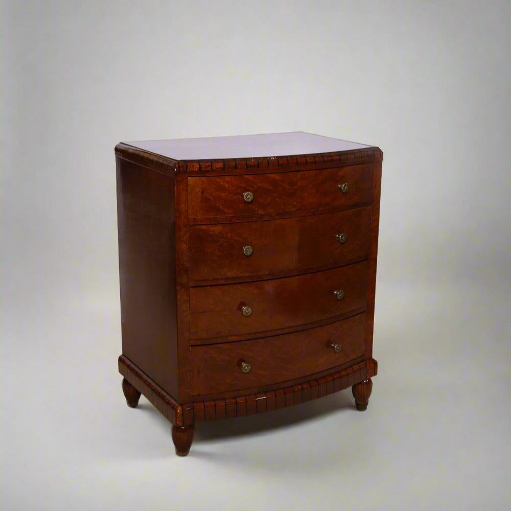 An Art Deco bome chest of drawers. Birds eye maple with ebony details and patinated bronze pulls.