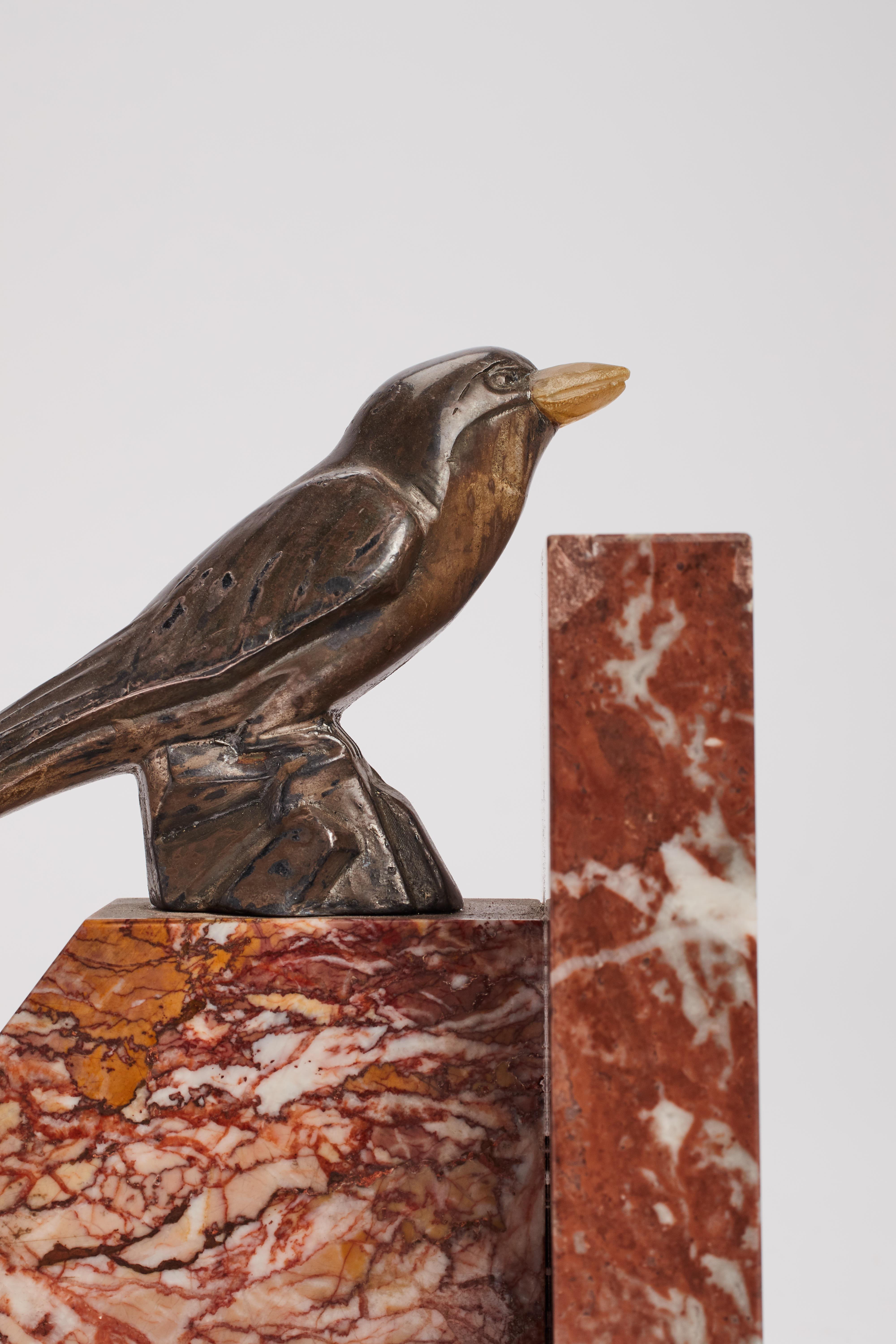 Pair of bookends red-veined marble from Verona with L-shape structure over the L-marble base, two identical white metal sculptures of bird’s swallow, with a Hornbeak. Art Deco. France, circa 1930.