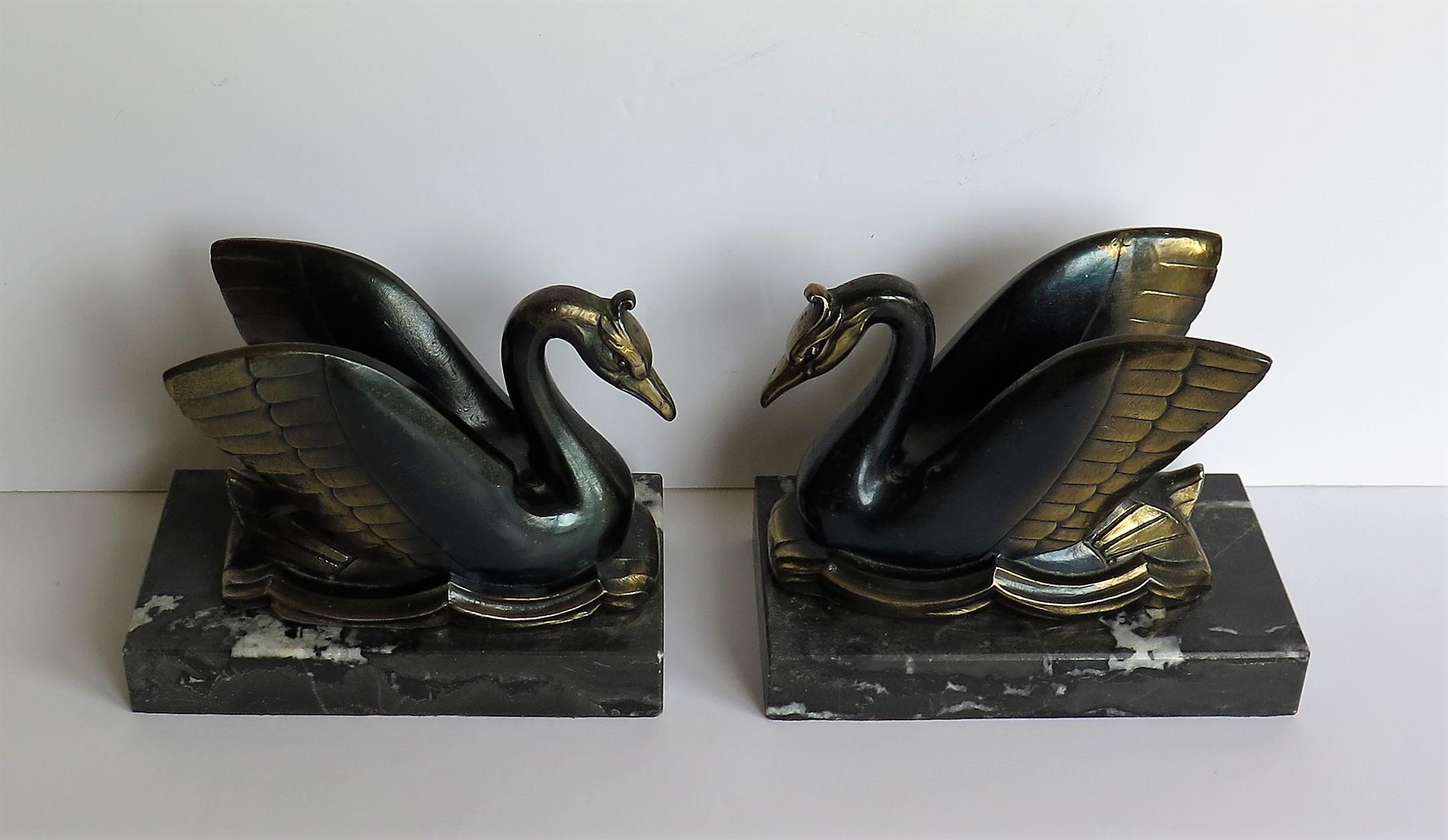 These are a beautiful pair of French, Art Deco period, book ends of two metal swans on black marble bases. 

Each swan has been well modelled with good detail and then cast in a heavy metal having a bronzed finish which has then been hand cold