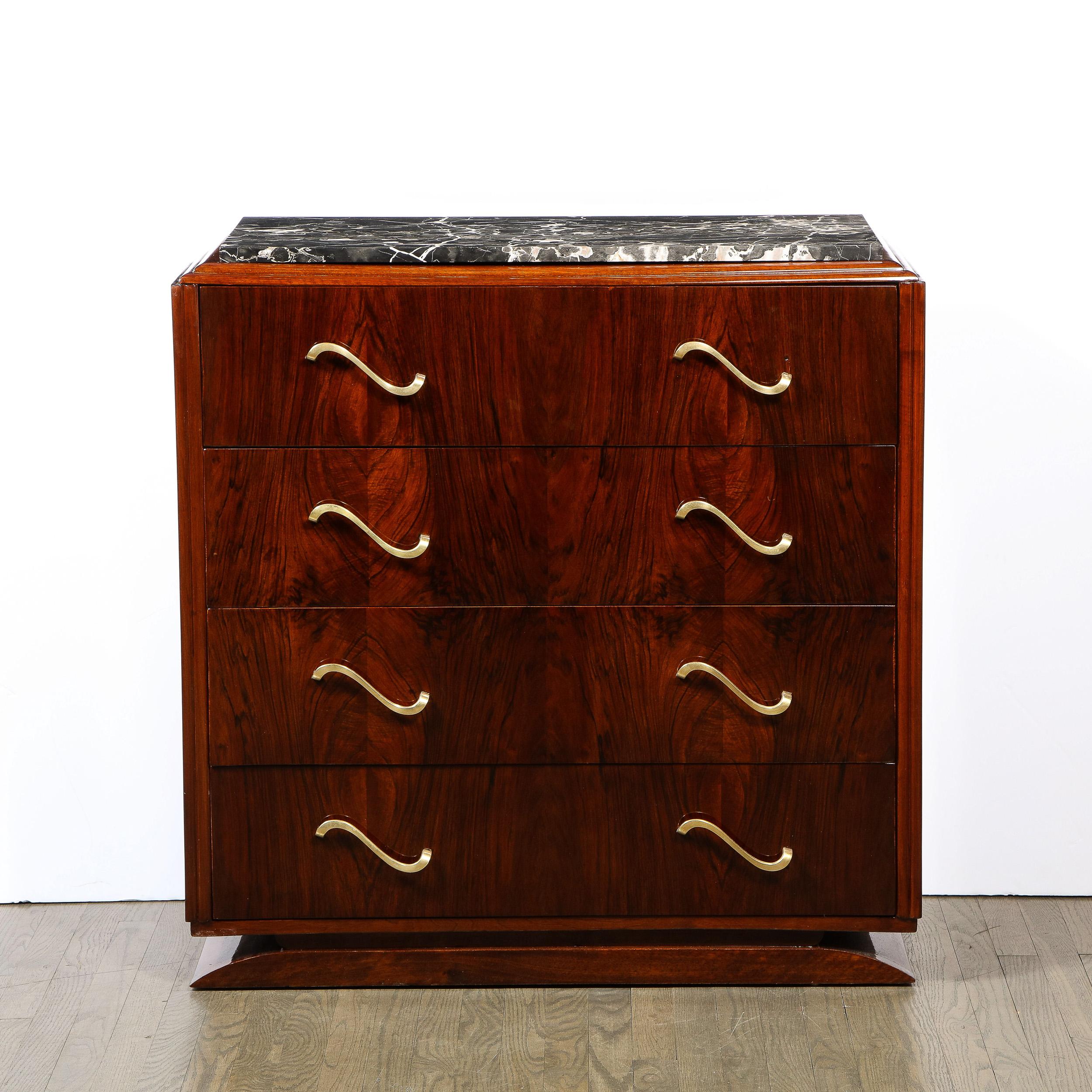 This elegant Art Deco sideboard was realized in France, circa 1940. It features a beveled base and a volumetric rectangular body with a tiered skyscraper style top- all in beautiful bookmatched walnut- with an exotic black marble top. The piece