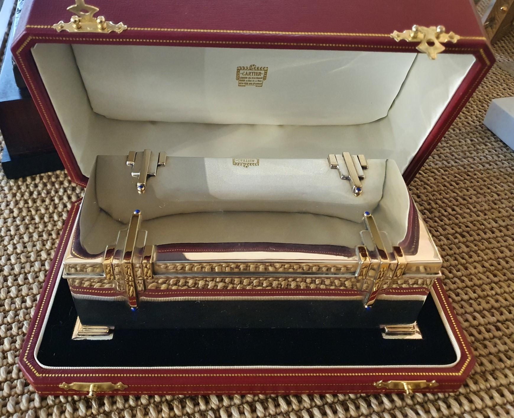 Cartier, New York

A magnificently stylish Sterling silver cigar box of high Art Deco style by Cartier, New York, circa 1930, the rectangular box with stepped pyramid motif set to the lid and sides in applied Sterling silver and 14ct gold, each