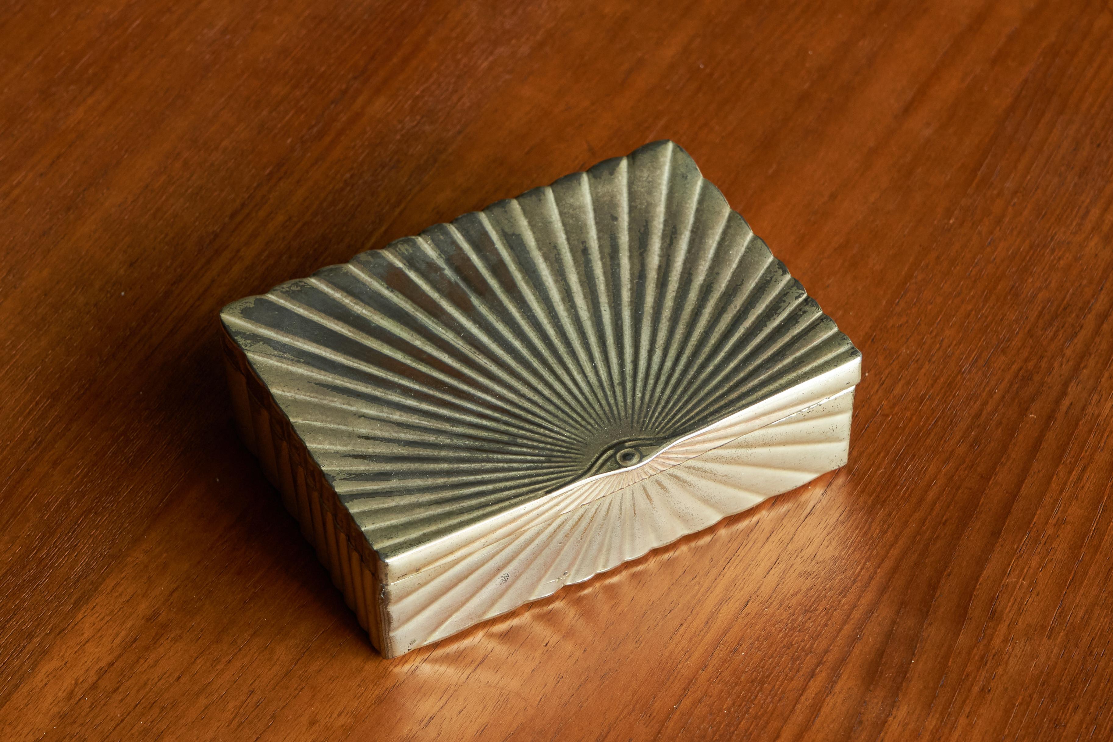 Wonderful art deco box in silver plate, mid 20th century.

This is a fine art deco style decorative silver plated box with a very distinct sunburst design.

Great as a decorative box on a desk, coffee table or cabinet. 

About ORNAMENTUM

ORNAMENTUM