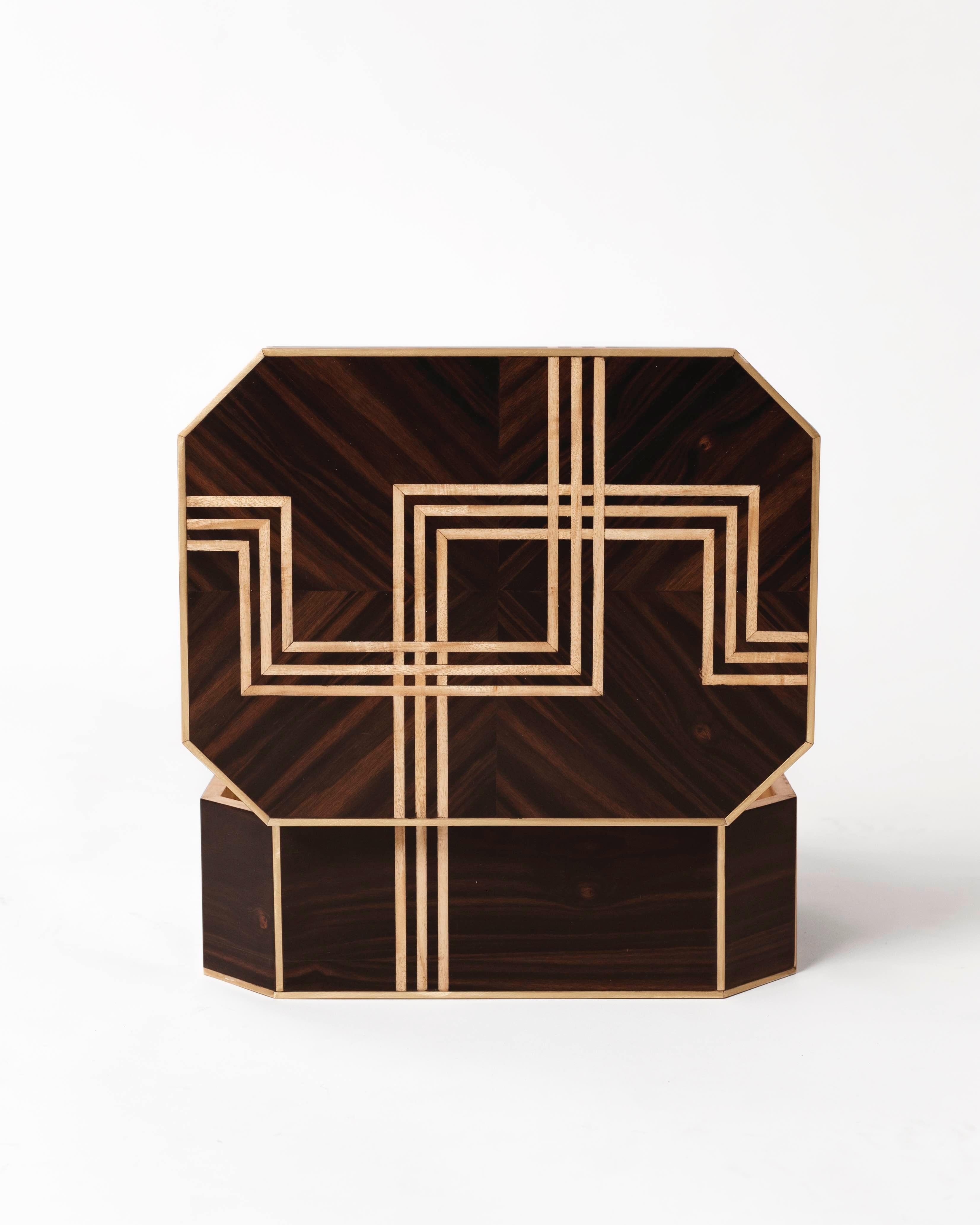 Large box built in spring wood with ebony veneer and geometric inlays in bronze and spring wood.

The influence for this piece came from Marion Dorn's design of the black and cream geometric patterned rug in the lounge of The Claridge's Hotel in
