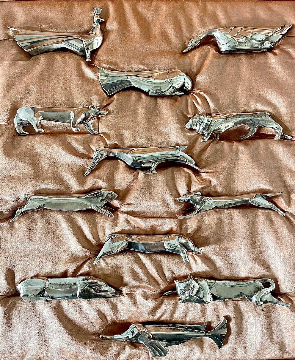 Art Deco set of 12 knife rests in their original fitted box

Each animal is silver plated and individually cast 

Fashioned in a Cubist style by the sculptor Edouard-Marcel Sandoz 
This design was first introduced for the 1st class dinning room on