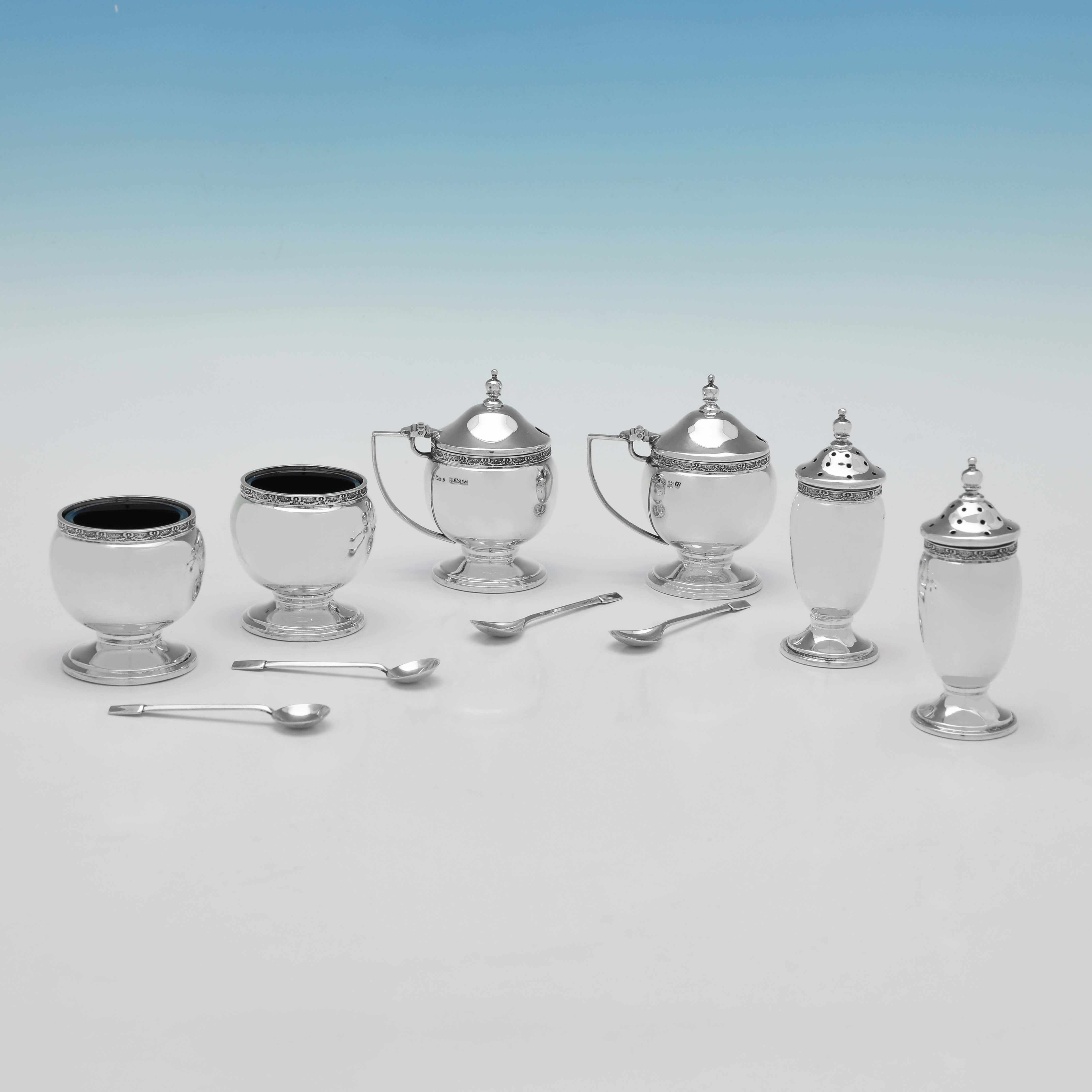 Hallmarked in Birmingham in 1937 by Roberts & Dore, this handsome, Sterling Silver Condiment Set, is in the Art Deco taste, and is presented in its original box. 

Each mustard pot measures 2.75