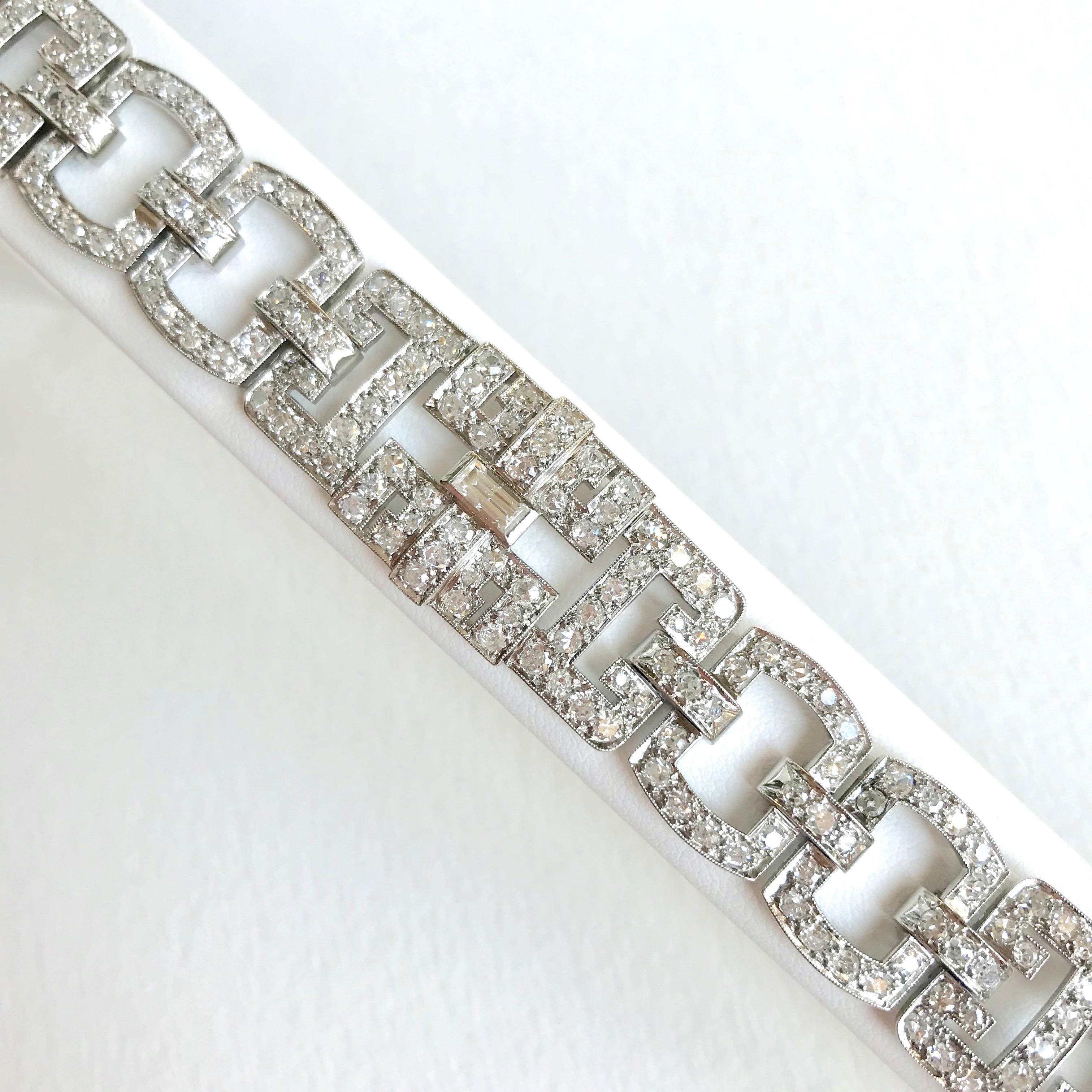 Armband aus Platin (950 °/°°°), bestehend aus 3 durchbrochenen geometrischen Mustern, ausgefasst mit Diamanten im Altschliff, veredelt mit Diamanten im Baguetteschliff. Unsichtbarer Ratschenverschluss mit Sicherheitskette aus Weißgold. Französische