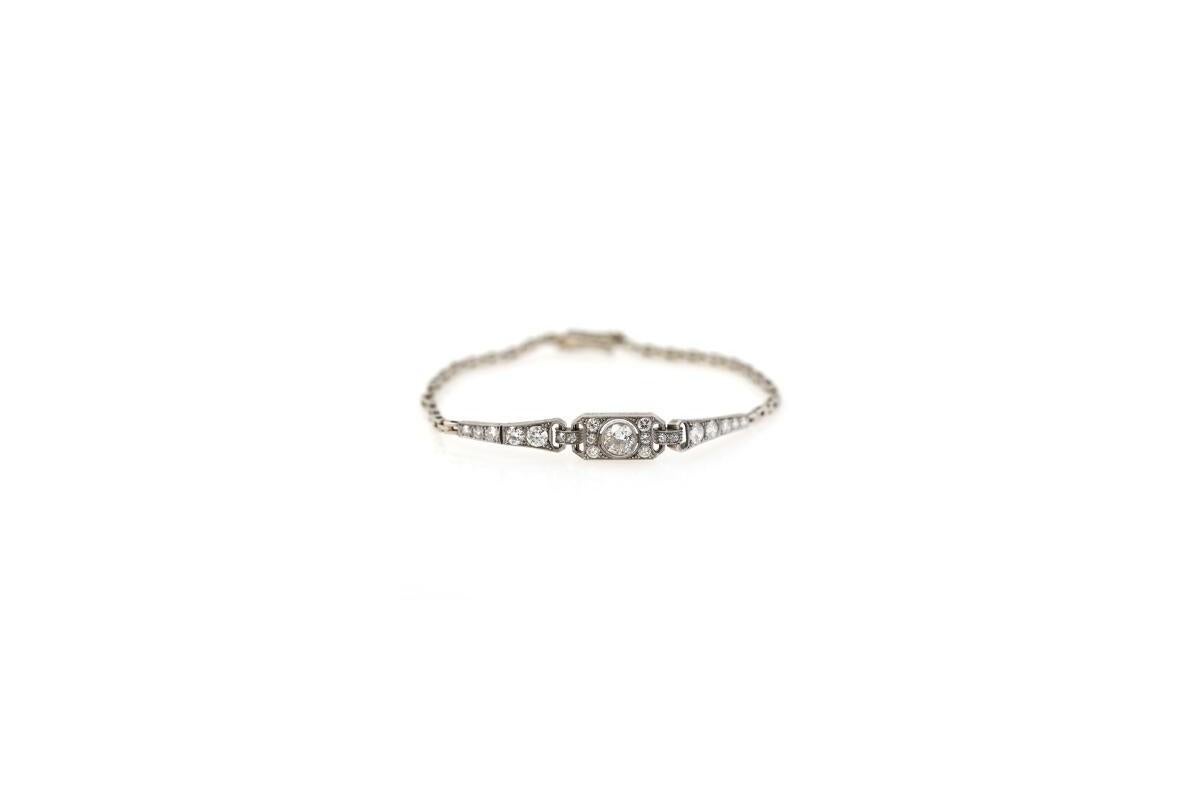 Art-Déco-Armband aus den 1930/40er Jahren, aus 14 Karat Weißgold (Feingehalt 0,585), mit weicher Struktur und sicherem Druckknopfverschluss.

Das zentrale Element ist mit hochwertigen Diamanten besetzt, der mittlere Diamant ist im 