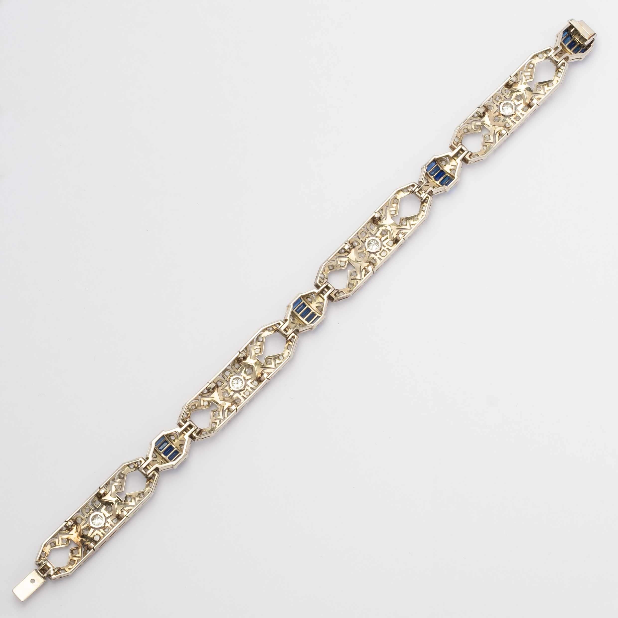 Refined Art Deco bracelet, finely crafted and hand-pierced in 18ct white gold. Its elegant geometric design is enhanced by rose cut and old-cut diamonds, while the central lozenges are accented with emerald-cut blue stones, alternating with the