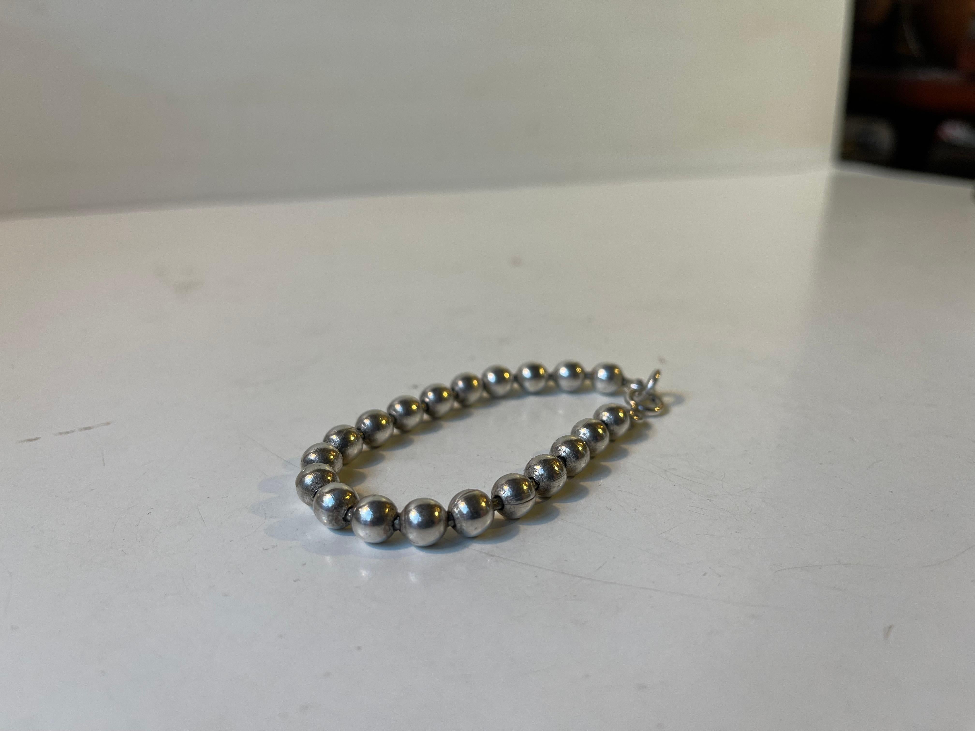 An elegant and simple beaded bracelet I 830s. Un-indentified European/Scandinavian maker circa 1920-40. A 'new' lock has been mounted. 

Measurements: L: 18,5 cm in total, pearl diameter approximately 5mm. 
Weight approx. 30 grams in total.