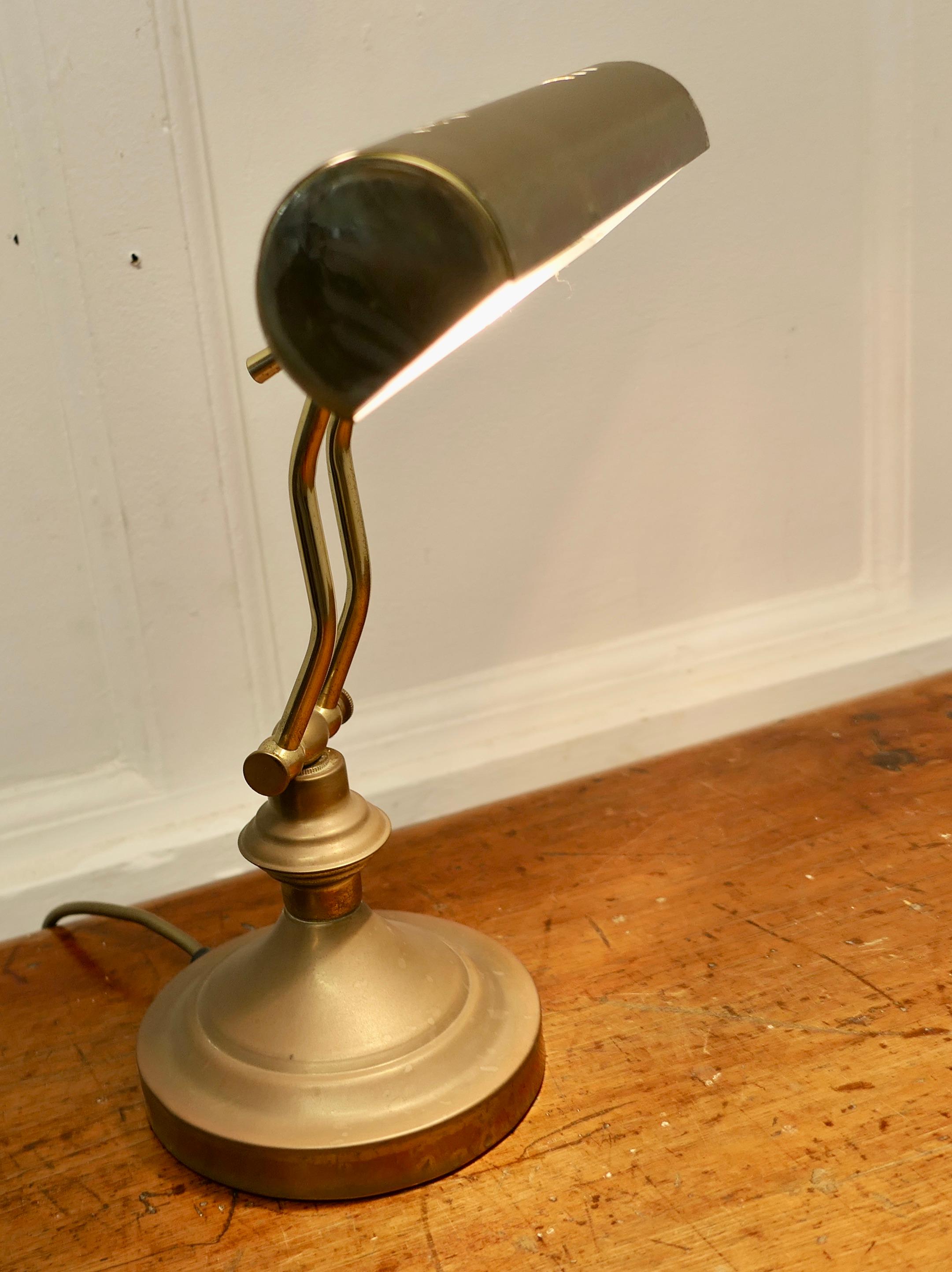 Art Deco Brass Adjustable Bankers Desk Lamp 

This is a great piece, the lamp has a round brass base which supports the swan neck arm, this in turn alters the angle and the long cylindrical lamp also swings up and down to adjust the light
The lamp