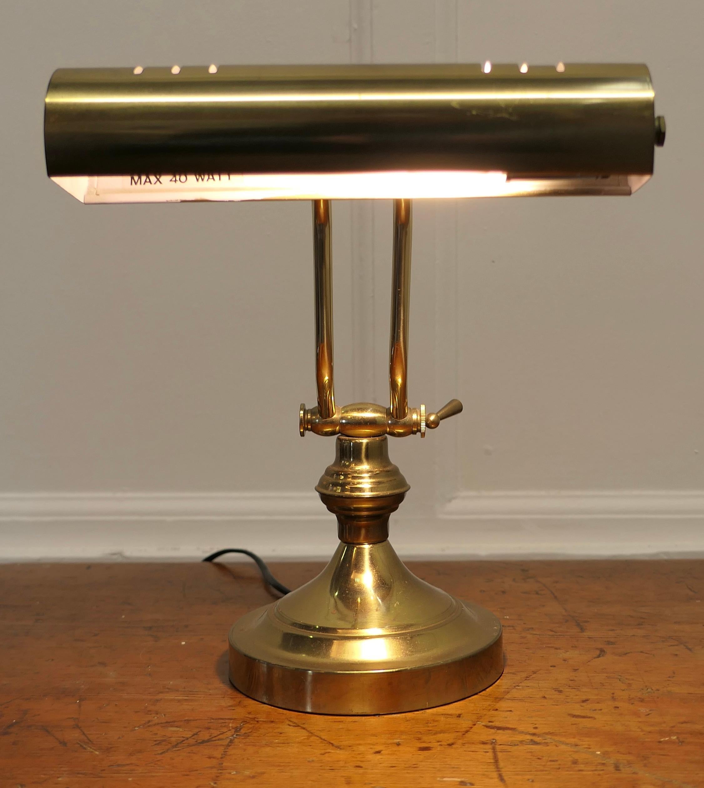 Art Deco Brass Adjustable Bankers Desk Lamp 

This is a great piece, the lamp is heavy, it has a round brass base which supports the swivelling swan neck arm, this in turn alters the angle and the long cylindrical lamp also swings up and down to