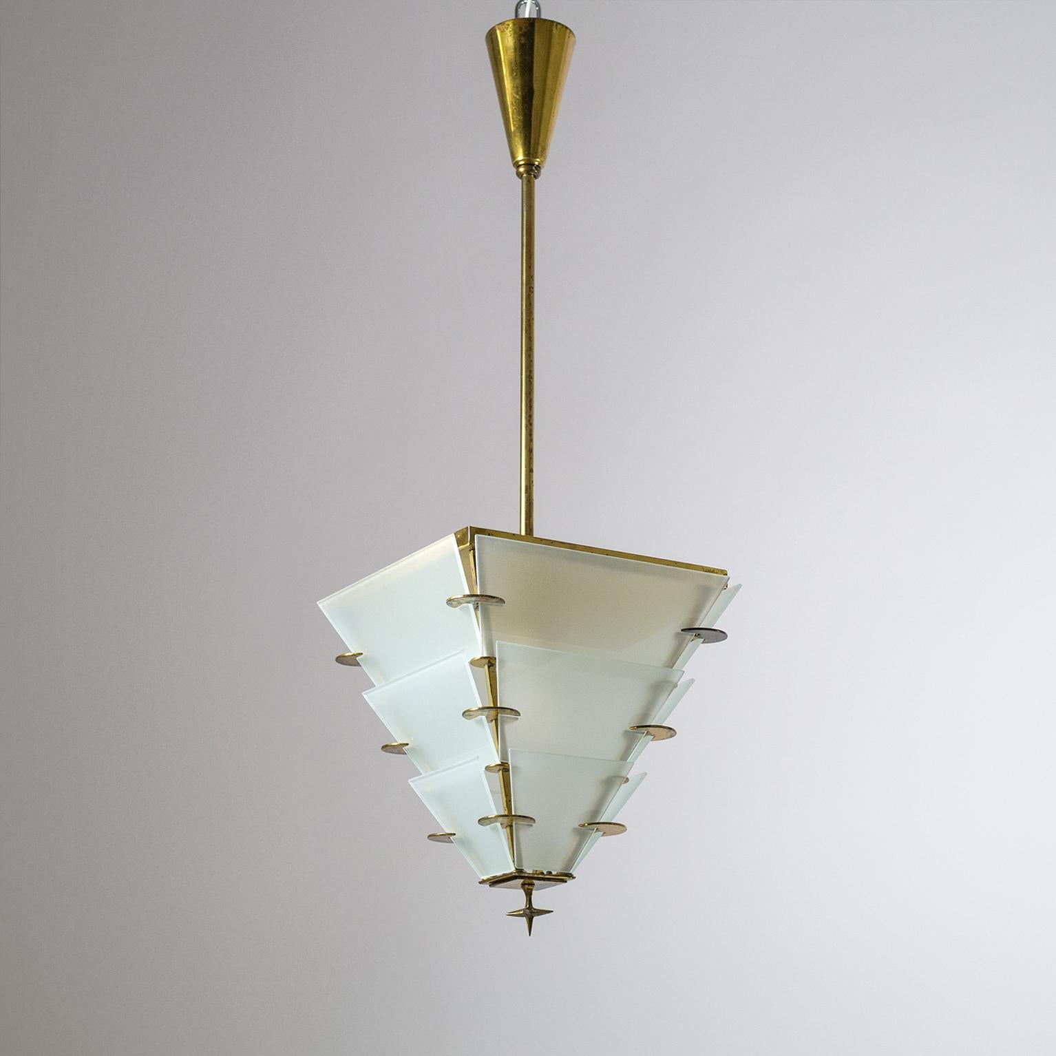 Very fine Art Deco lantern in brass with tiered satinated glass elements. The inverted pyramid shaped lantern culminates in a star-shaped brass finial. There is a good amount of age-related patina throughout on the brass. One original brass and