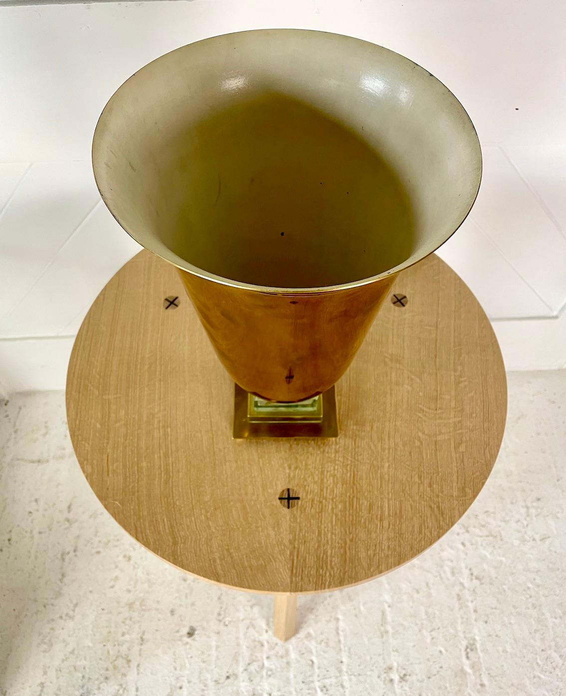 A wonderful Art Deco French brass and glass table lamp

With incised line decoration to the top

Enamelled cream interior

On a glass stepped base and small ball feet

Re-wired

Circa 1930s