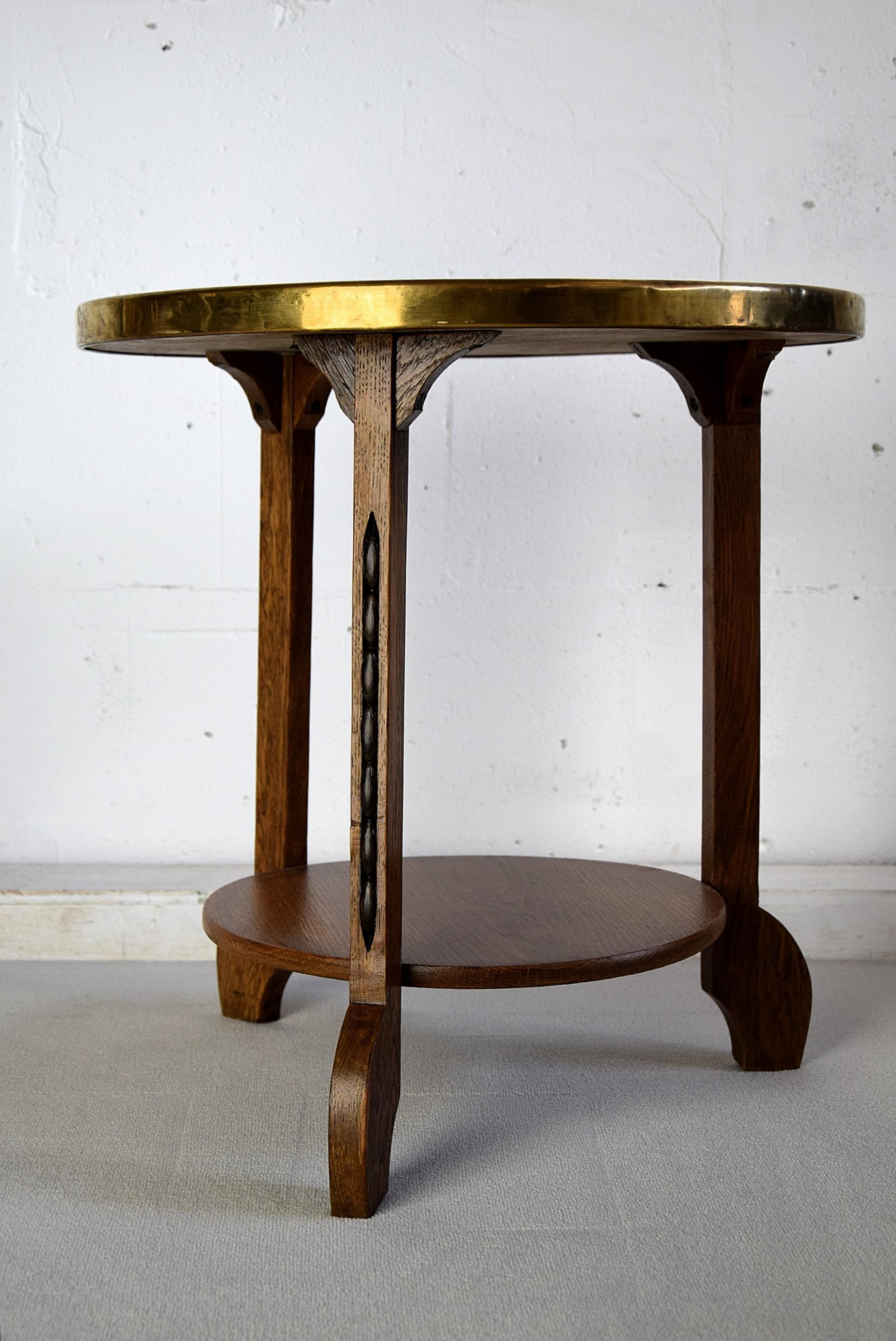 Rare 1920s Art Deco brass and oak side table with decorated brass top. This piece was produced in the Netherlands circa 1920. The table top was made in Persia and brought to the Netherlands by traders. Than the top was used by Artigiani who turned
