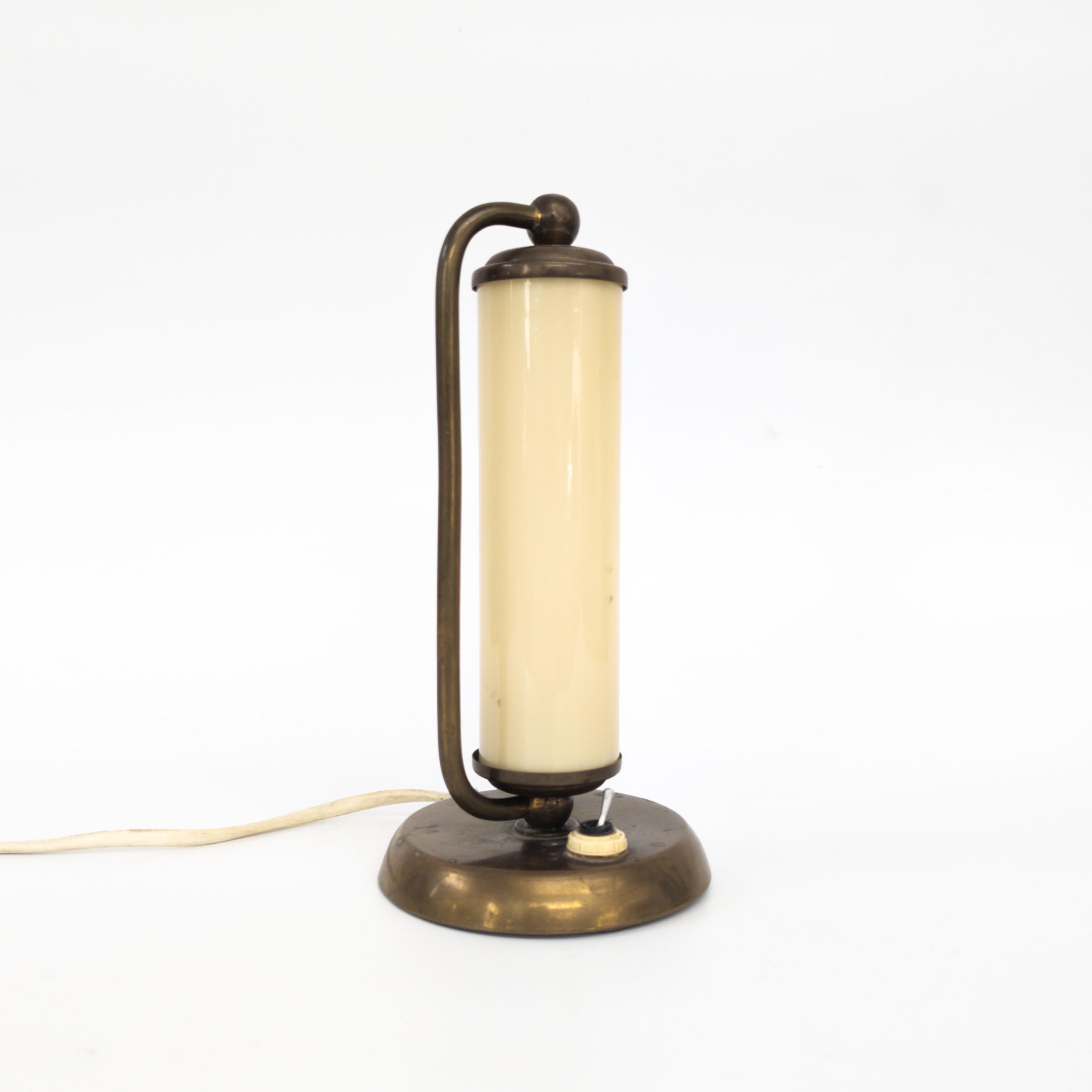 Lampe de table fabriquée par Napako, dans l'ancienne Tchécoslovaquie, dans les années 1930. Belle lampe de chevet Art Déco en laiton avec un abat-jour cylindrique en verre opalin. En bon état d'origine, entièrement fonctionnel.
