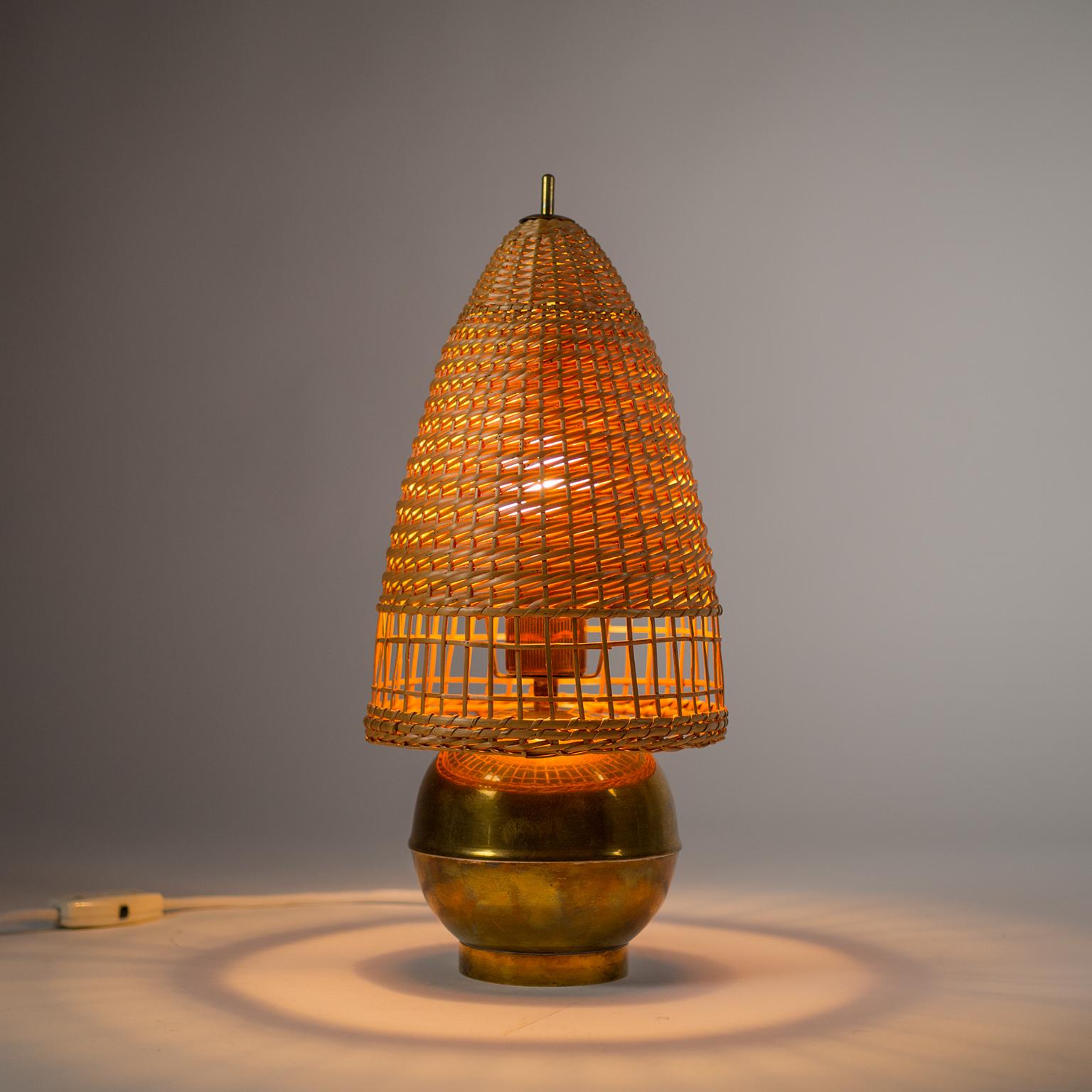 Delightful Art Deco table lamp from the 1940s in brass with a rare slender wicker shade. Very nice original condition and casts a lovely warm and indirect light effect. One original bakelite E27 socket with new wiring.