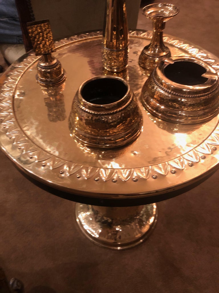 Art Deco brass and wood smoking table, made in Germany pre WW 2. 5 pieces in total for smoking: cigarettes, matches, ash tray candle and bud vase. The top is hammered with a three dimensional lotus flower design going around the top, sitting on a