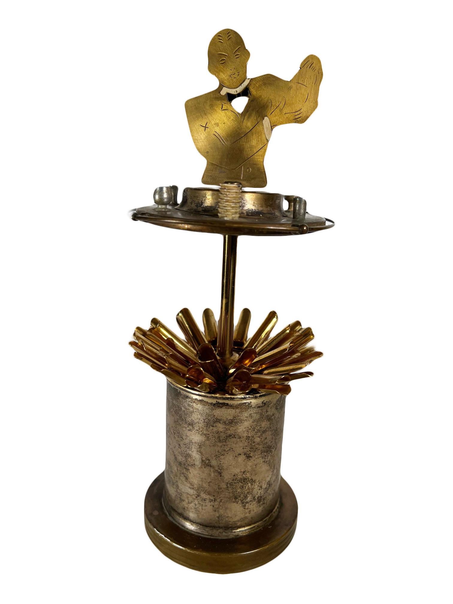 A rare art deco mechanical bartender. Engraved gold metal figure raises to display contents. Steel and brass. Germany, circa 1930s. 