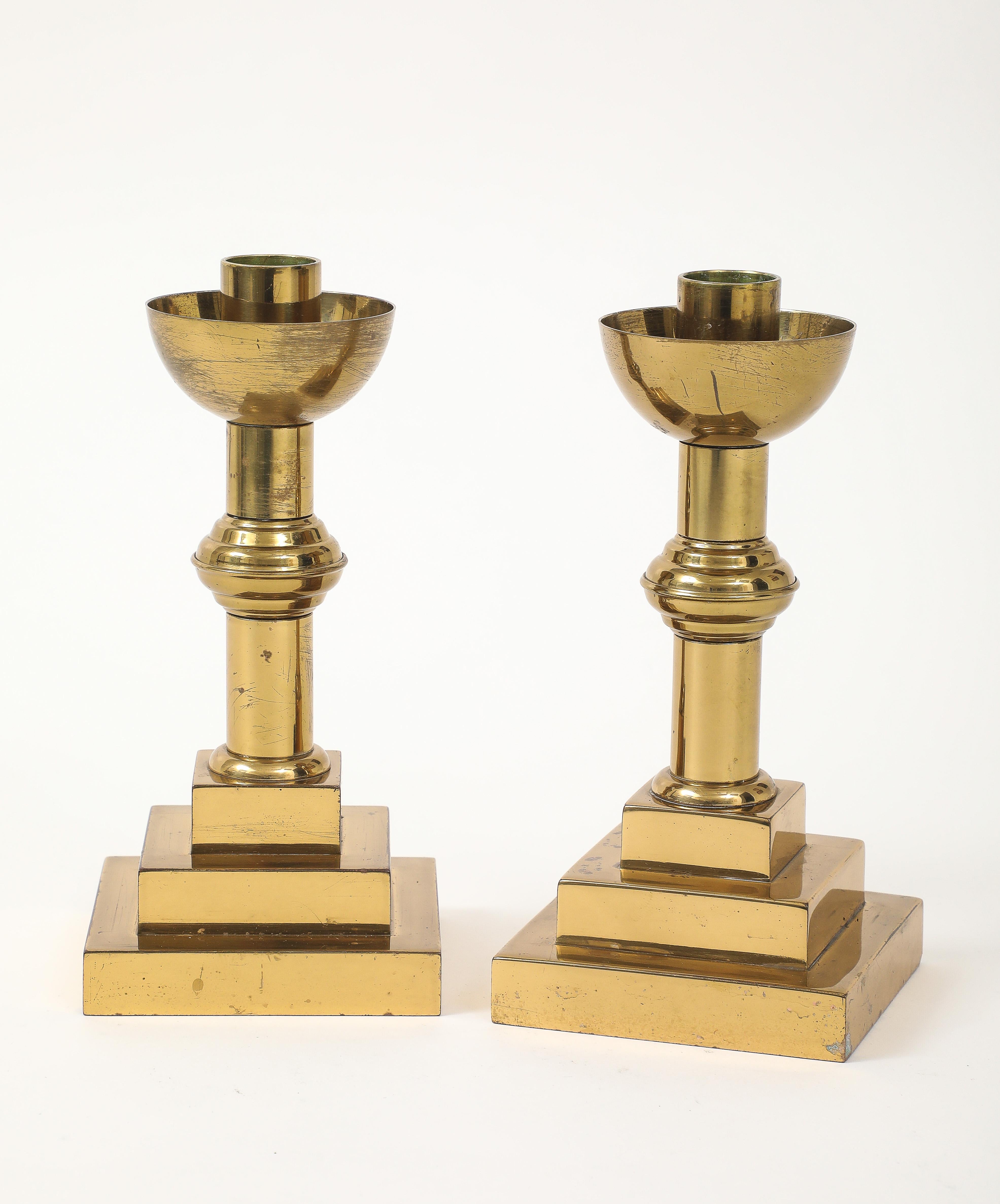 Coppia di candelieri Cathedral Art Deco in ottone invecchiato con base a gradini.