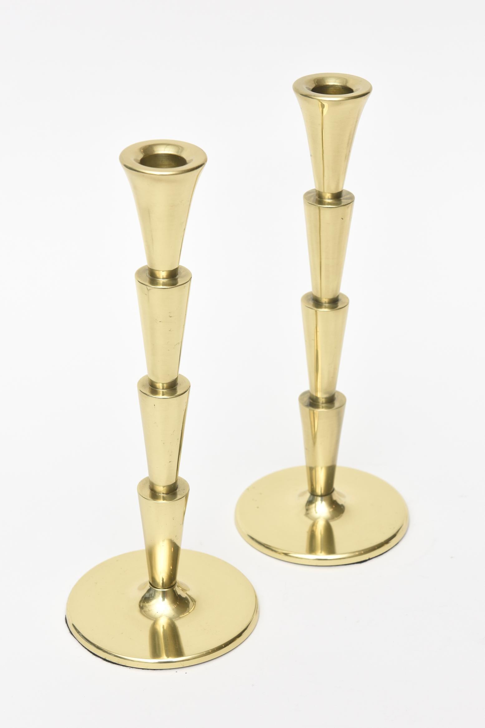 These lovely pair of polished brass Art Deco candlesticks have inverted half conical as the column-form. They sit on a round base. They remain today modern and neutral. They are solid and have great weight. New black felt was put on the bottom. They