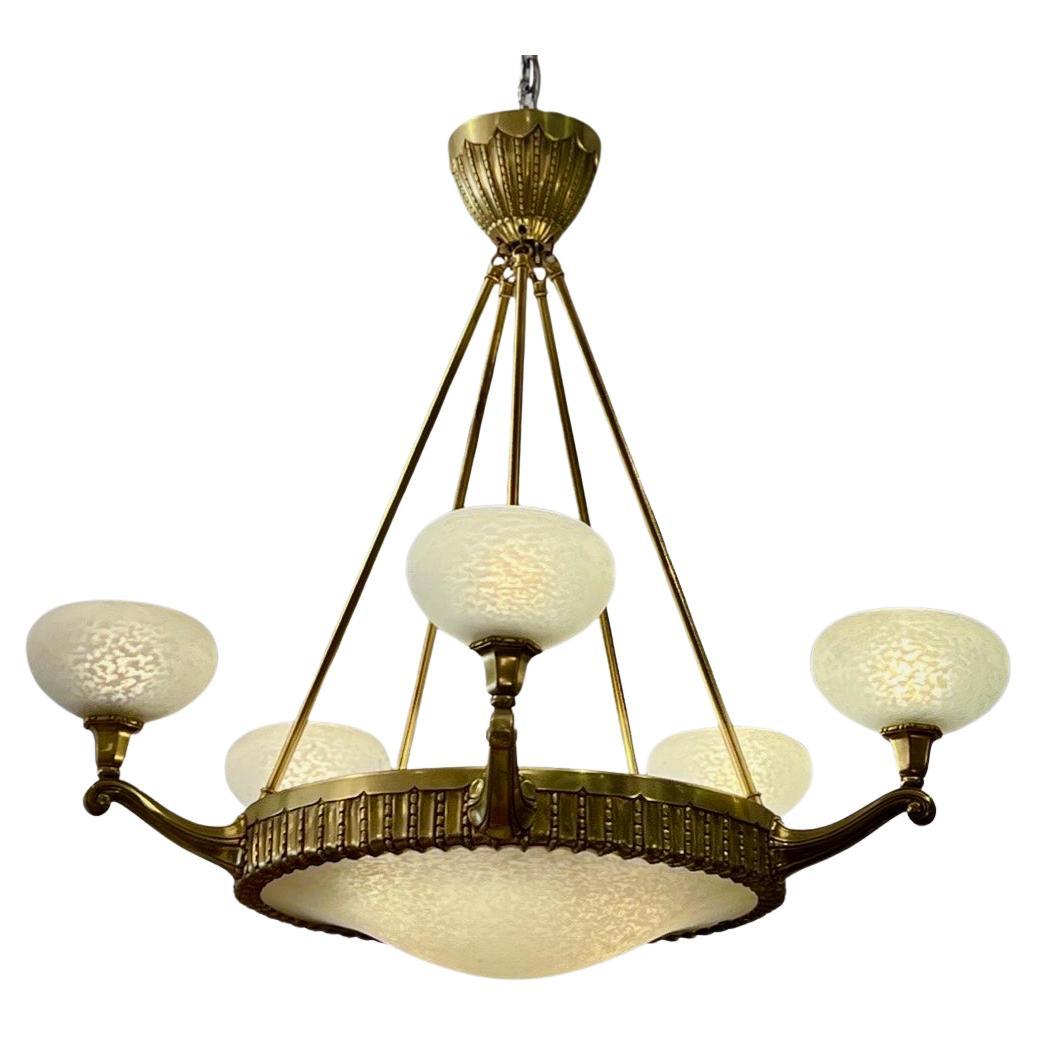 A beautiful Art Deco chandelier made of highly worked bronze with a center glass plafonnier and five glass shades all signed Schneider.
Made in France 
Circa: 1930
Signature: 
