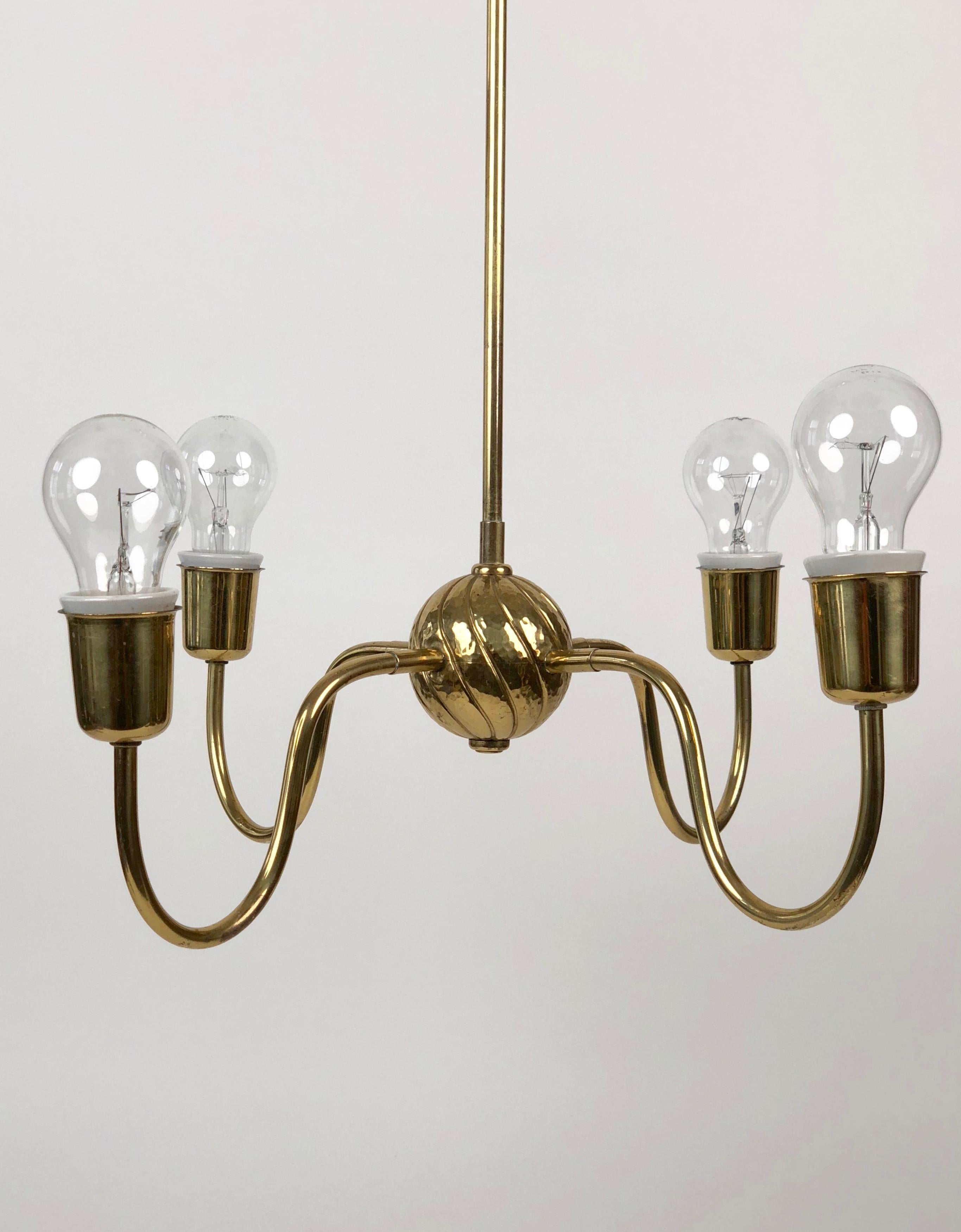 An Art Deco brass chandelier from the 1930s, made in Austria. This four-armed light has at its center, a hand hammered brass ball with spiral grooves that add a decorative element to this minimalistic form.

  