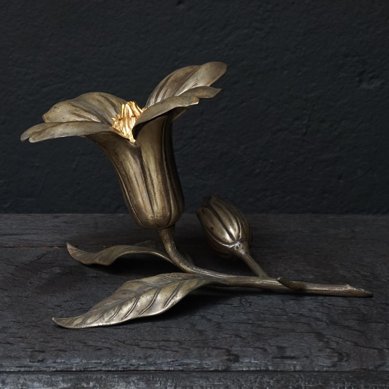Unique heavy metal and brass floral removable petals ashtray with cigarette dispenser and matchstick holder flower bud from the Art Deco era.
The four petals of the flower remove easily, and when flipped over become ashtrays. 
In the flower heart
