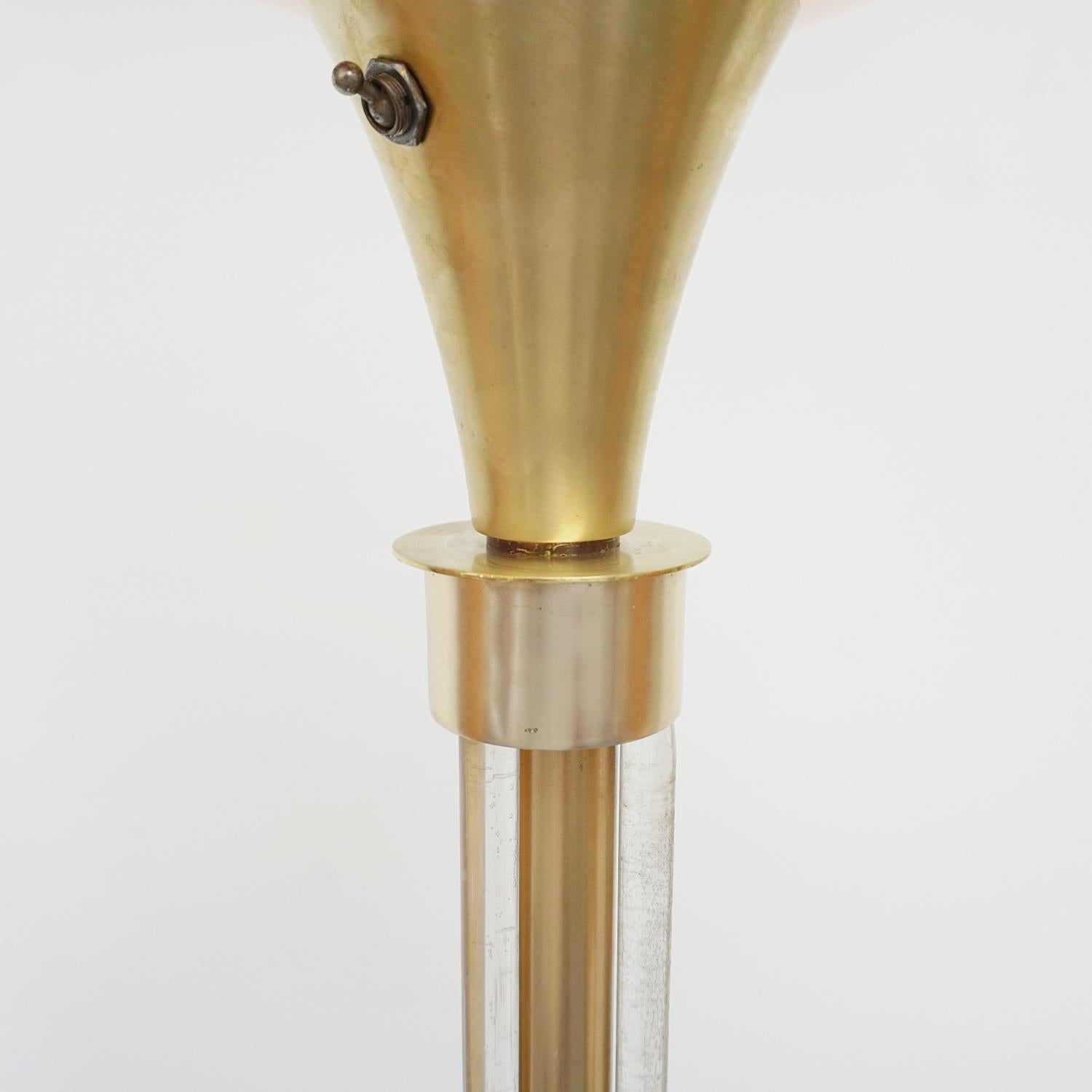 Eine Stehlampe im Art-Deco-Stil. Schirm aus gesponnenem Kupfer über einem Schaft aus Messing und Aluminium mit gebündelten Glasstäben. Auf einem runden Kupfersockel. 

Abmessungen: H 174cm, T des Schirms 35,5cm, T des Sockels 30cm.

Herkunft: