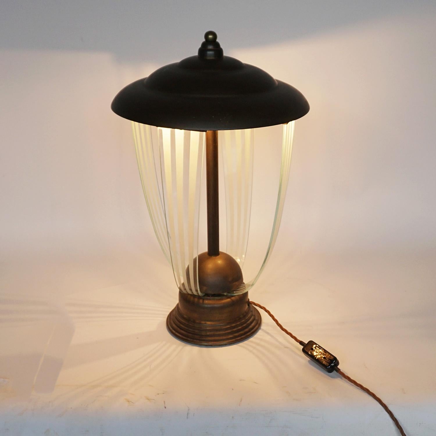 An Art Deco decorative table lamp. Four curved glass connectors outside of a central copper rod. Copper graduating shade and circular copper base. Brass ball finial to top.

Dimensions: H 49cm D 30cm 

Origin: English

Item Number: