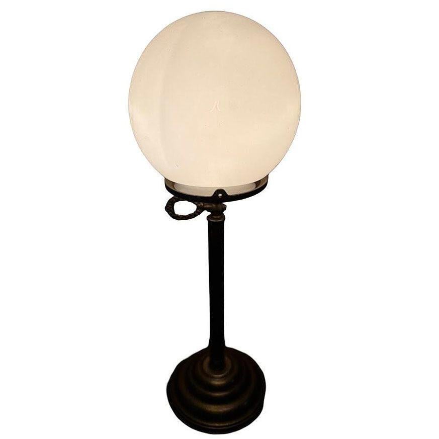 Art Deco brass desk or table lamp radiates timeless elegance with its column design and polished golden finish. The lamp features a traditional pedestal design with modernist influence hardware and was usually seen in banks and newspaper offices.