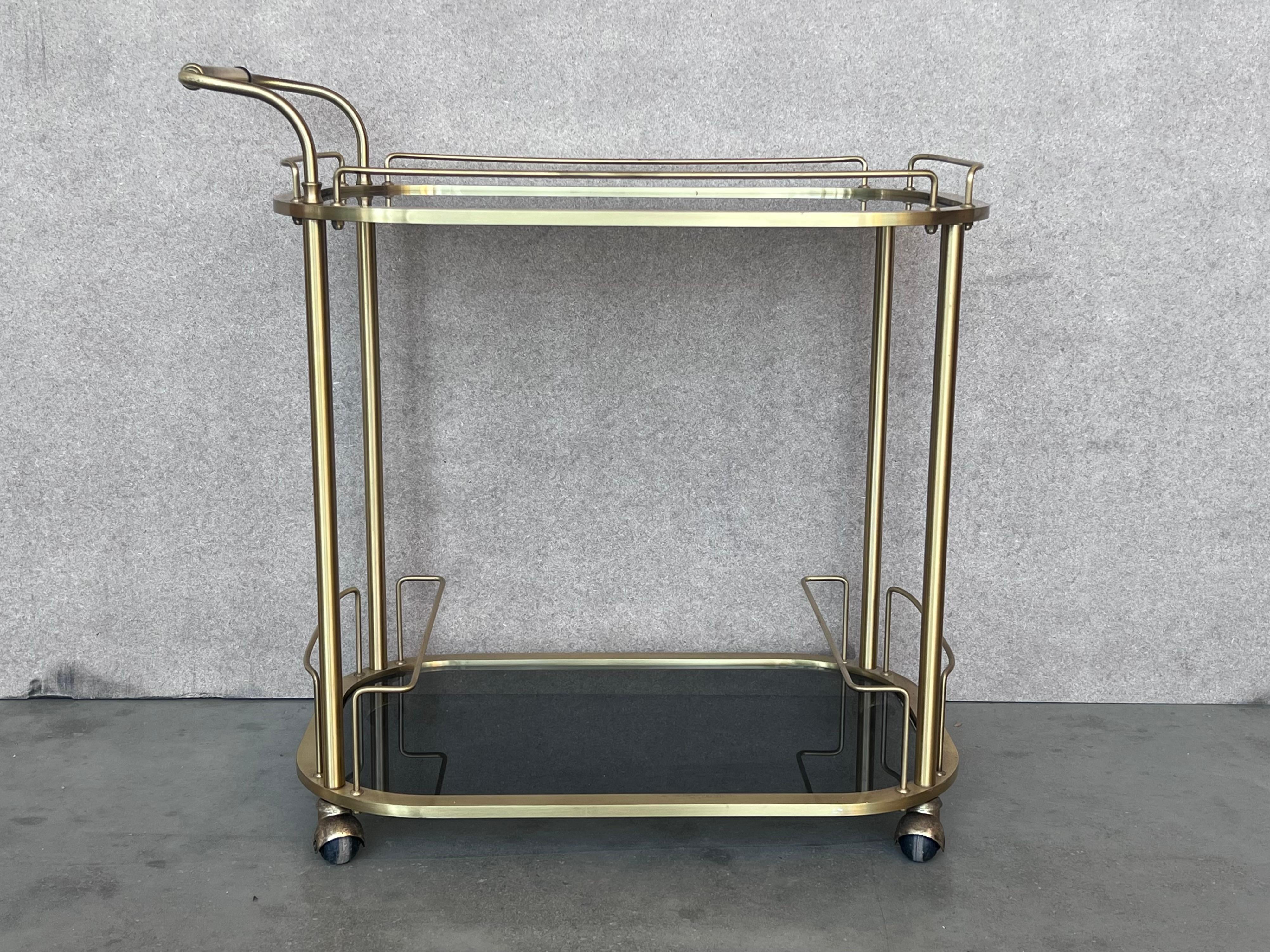 Fabulous brass bar cart with smoked glass
Proudly showcase your finest decanters and stemware! Brass handle. 
 This piece is in very good original condition and shows it was well cared for.