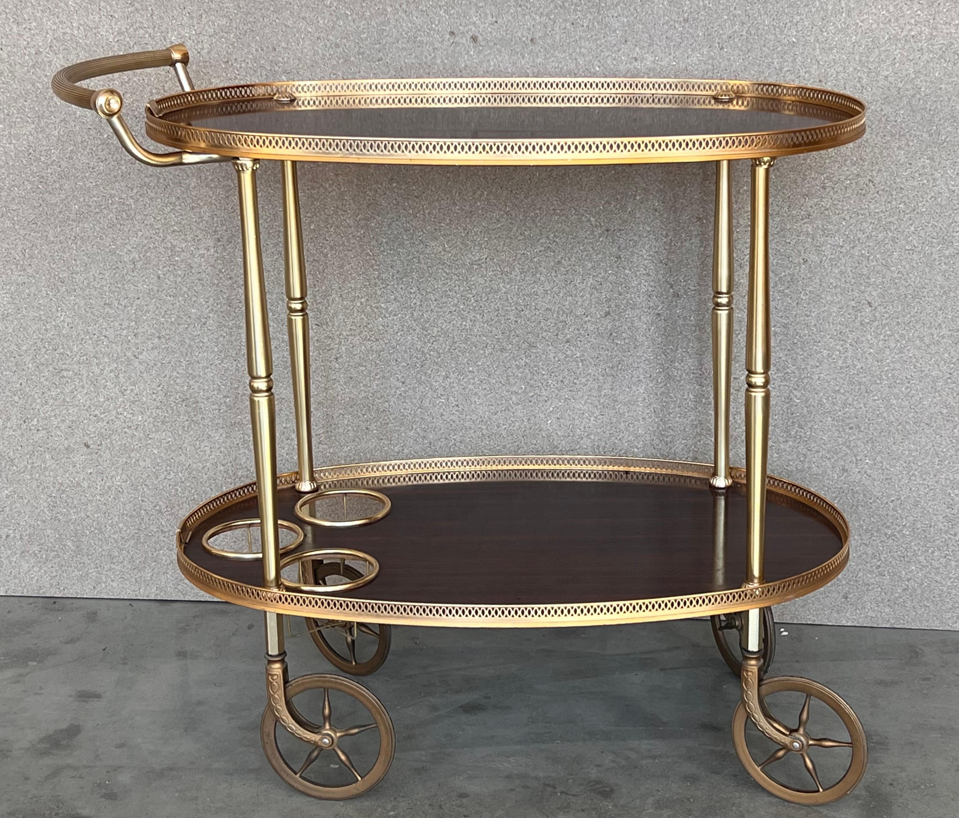 Fabulous brass bar cart with smoked glass
Proudly showcase your finest decanters and stemware! Brass handle. 
 This piece is in very good original condition and shows it was well cared for.