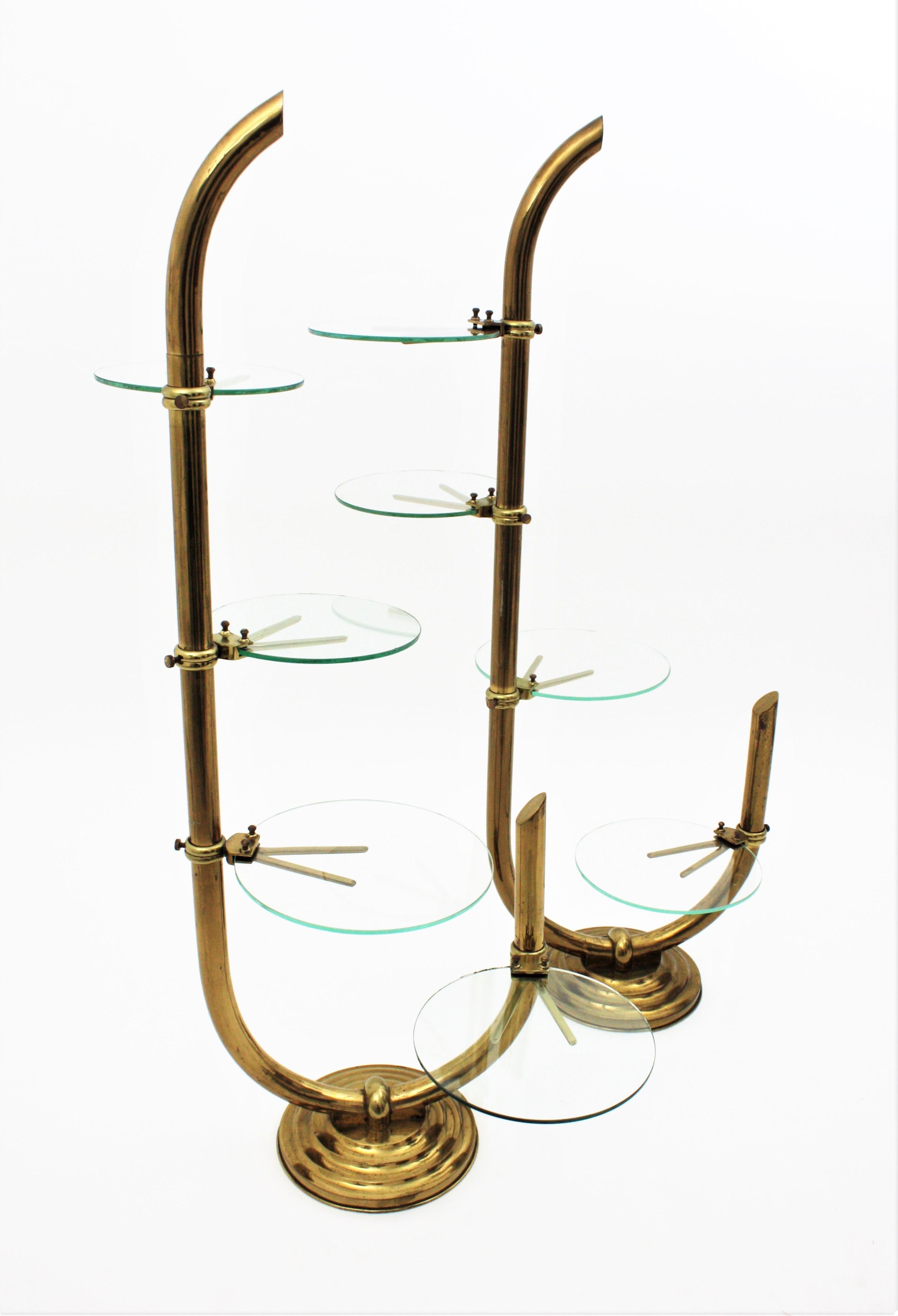 Pair of brass and glass floor shop display étagère with swivel glass shelves. Spain, 1930s.
This outstanding pair of brass display stands comes from an Art Deco period fashion shop in Barcelona. 
They feature a strong structure in brass holding 4