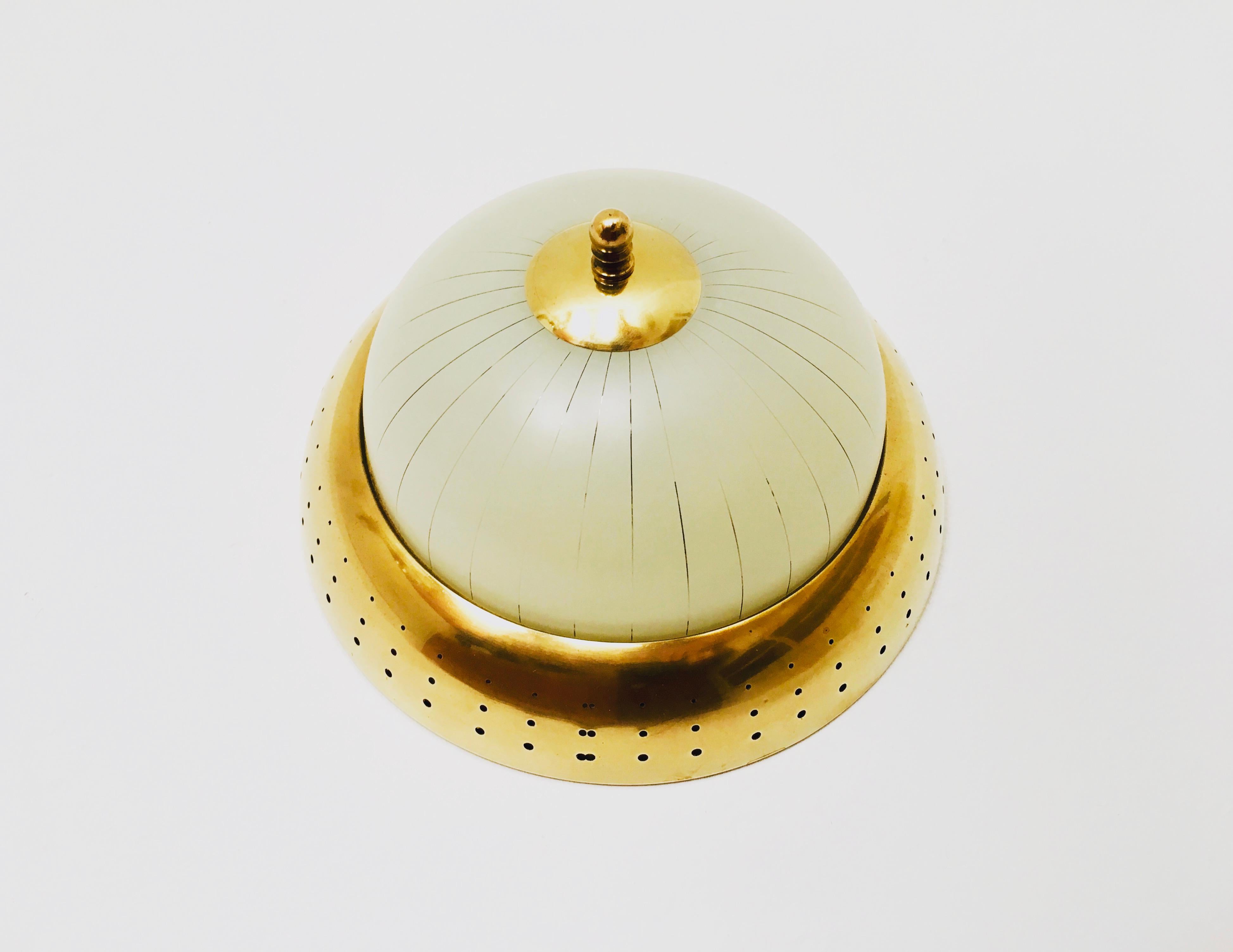 Wonderful brass ceiling lamp from the 1930s.
Loving details and high-quality workmanship.
The perforated brass ring and the cut glass create an enchanting play of light.

Condition:

Very good vintage condition with slight signs of wear consistent