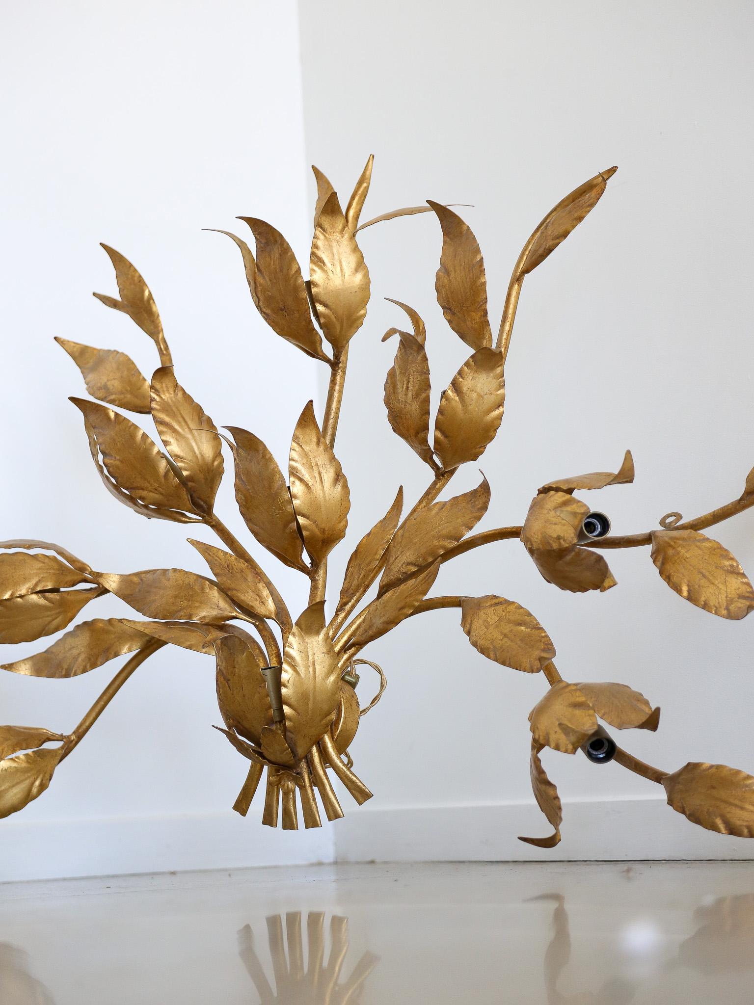 Les grandes appliques Art-Leco en laiton et ornées de feuilles d'or étaient un choix de design courant à l'époque de l'Art-Deco. Ces appliques se caractérisaient par leurs designs élégants et géométriques, incorporant souvent des matériaux luxueux