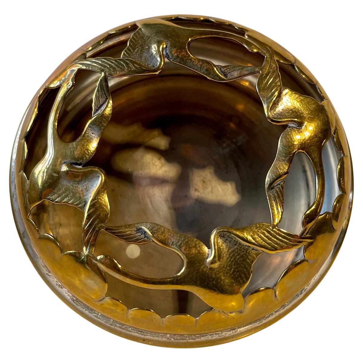 A decorative incense bowl - potpourri dish with a perforated top-mesh with interconnected swans. It made from brass and it is partially silver plated. It was designed and made by Jewelry Firm B&T in Denmark circa 1930-35. Measurements: D: 13.5 cm,