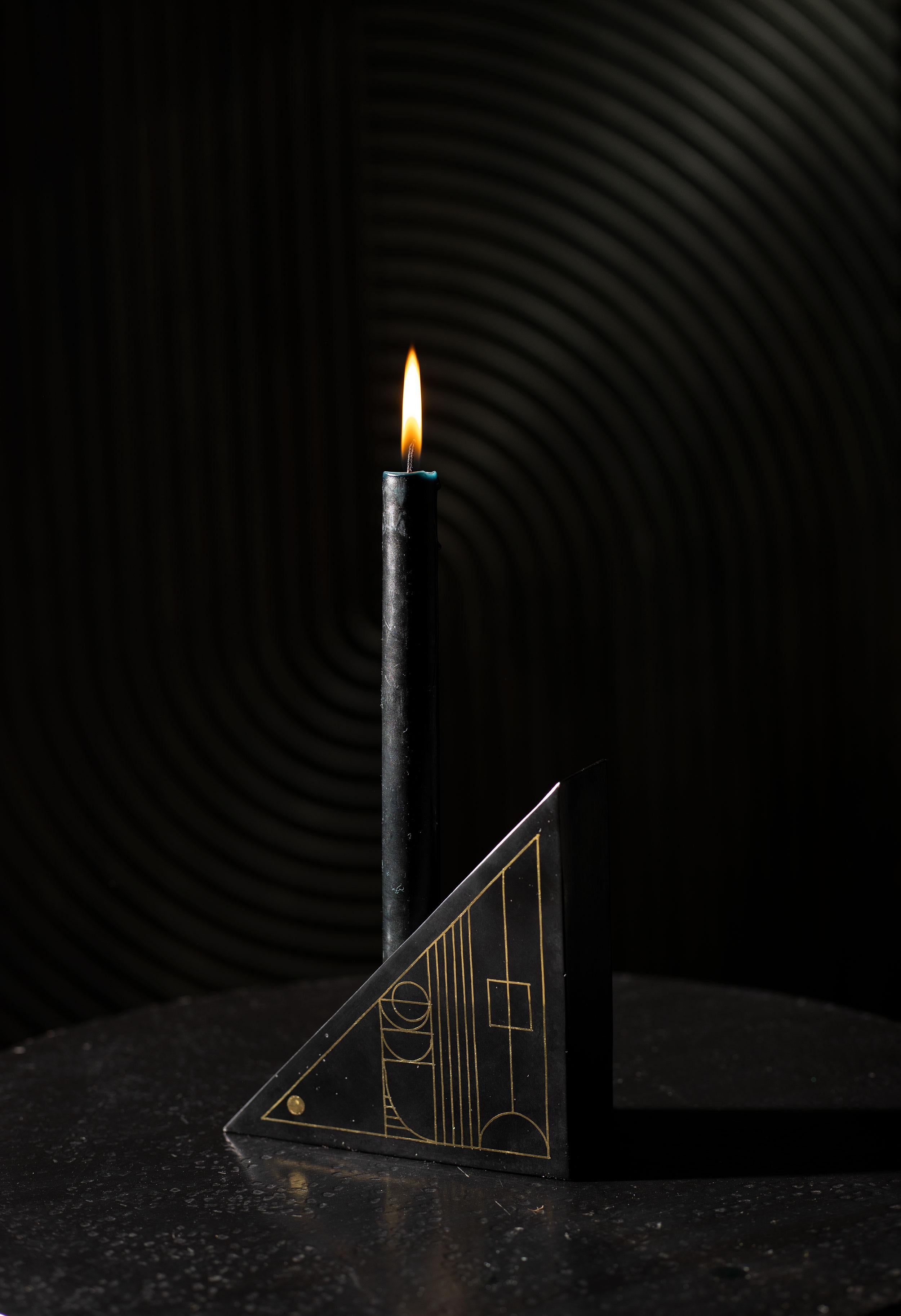 Our Art Deco-inspired candleholders are ethically handcrafted by artisans in Southern India using a technique that is native to the region. The artisans use a metal alloy that is blackened with a locally found soil, and the piece is inlaid with