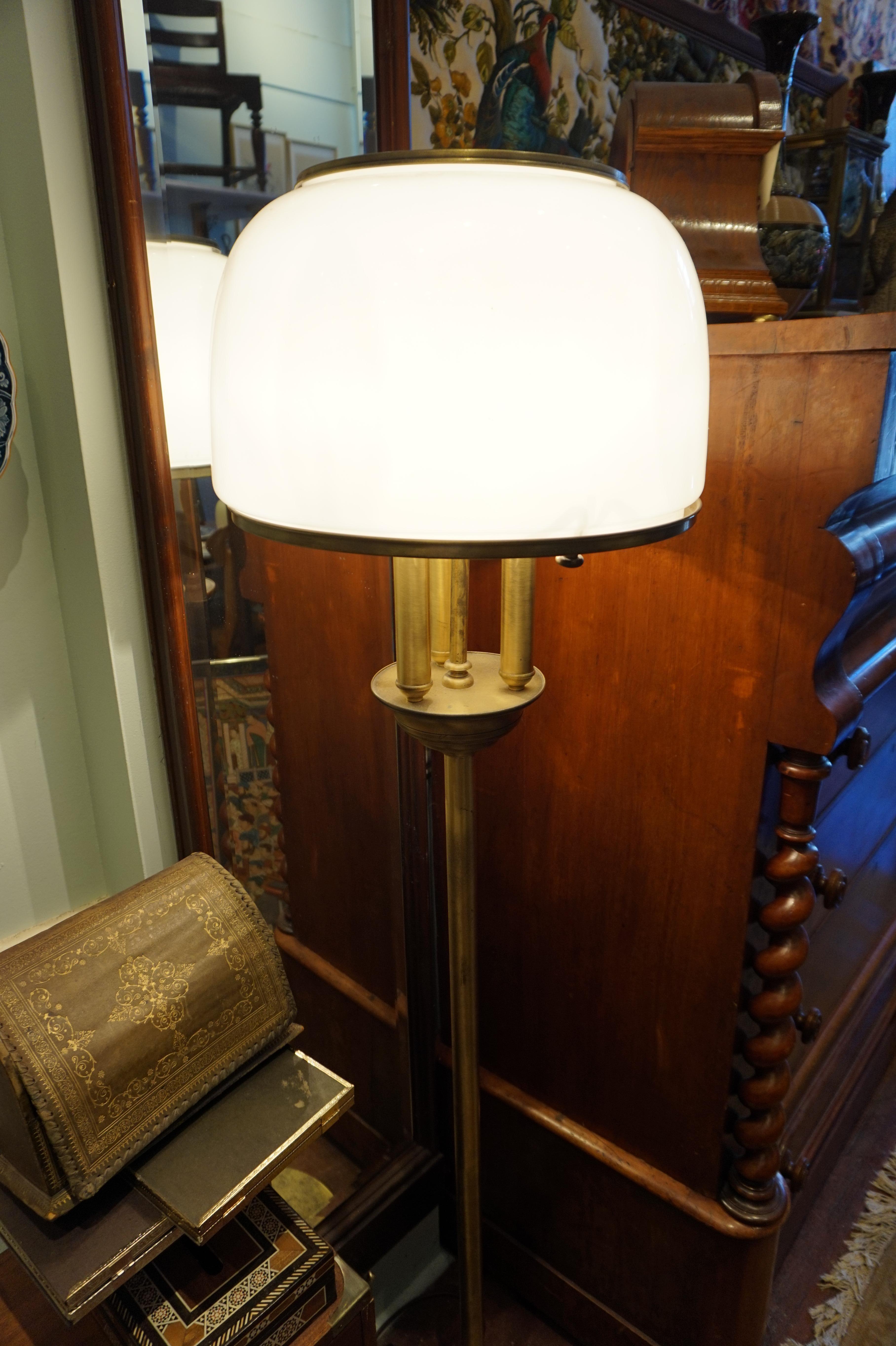 Brass lamp from the Art Deco era with original milk glass shade. Wiring renewed and converted to push pedal switch. Works well. Some patination on the brass consistent with age.

1930-1940.