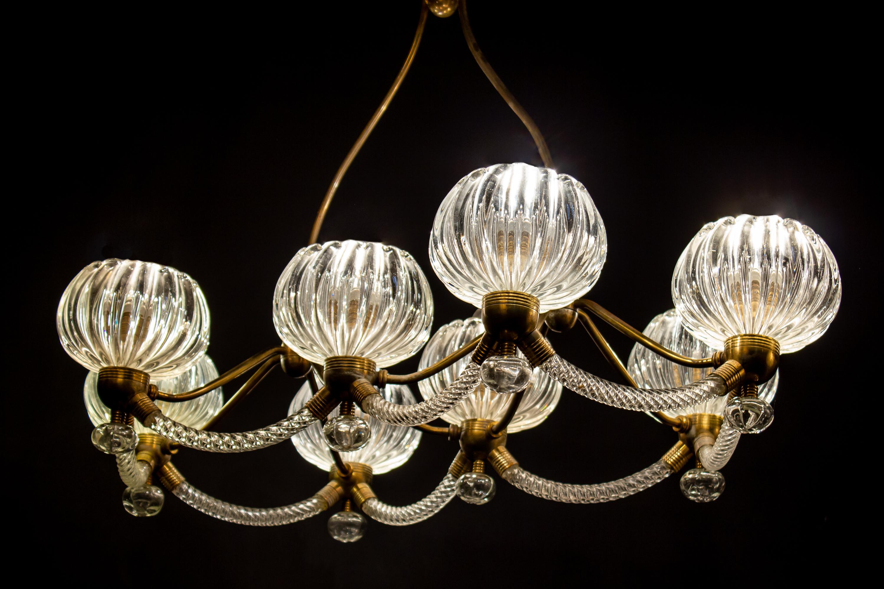 Sensational eight shade Murano glass chandelier with elegant shaped brass mount, by Ercole Barovier.
Excellent vintage condition.
Eight E 27 light bulbs compatible with US standards.
