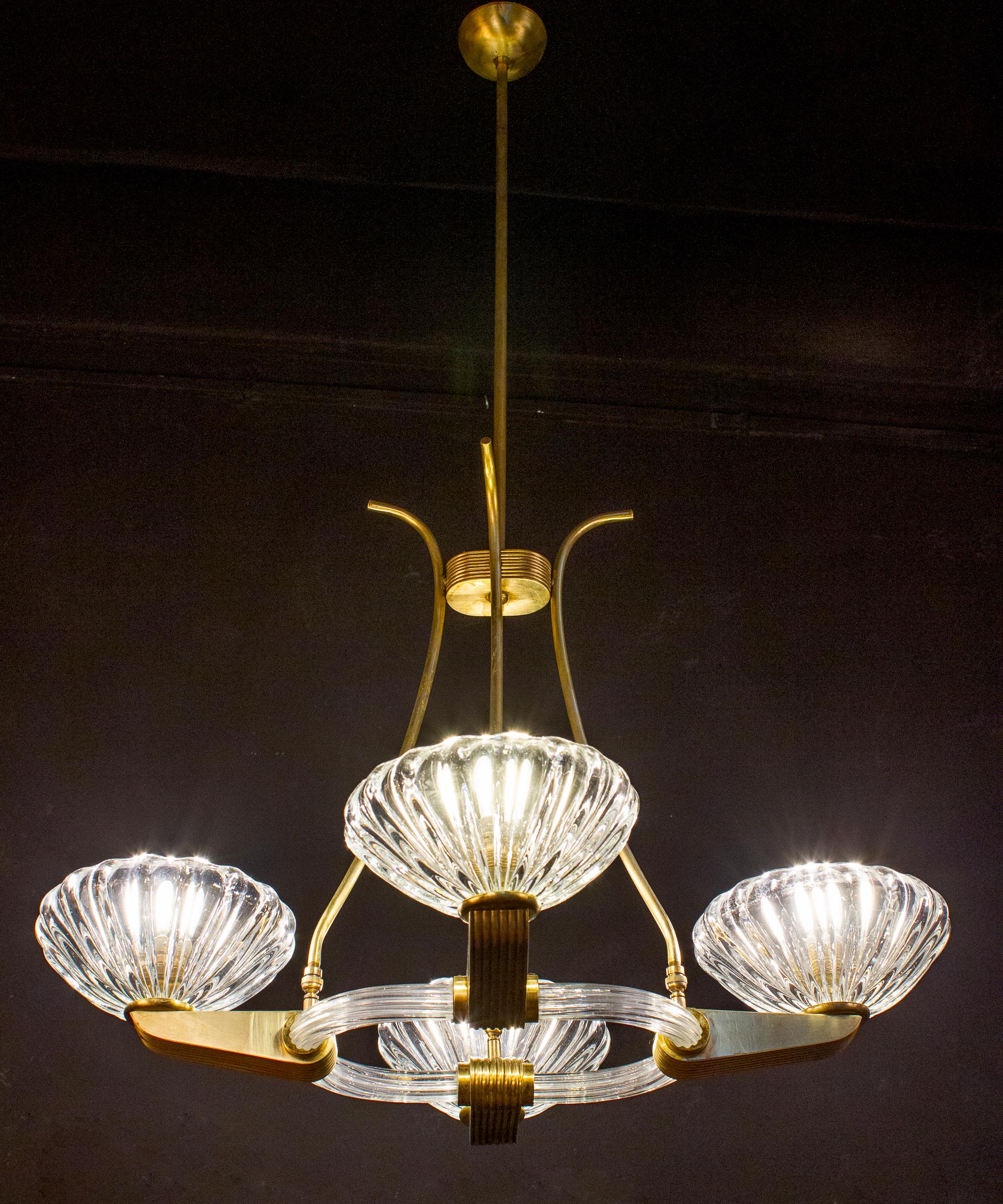 Elegant four-shade Murano glass chandelier with elegant shaped brass mount, by Ercole Barovier.
Excellent vintage condition.
Four E 27 light bulbs compatible with US standards.
The height of the brass rod can be shortened.