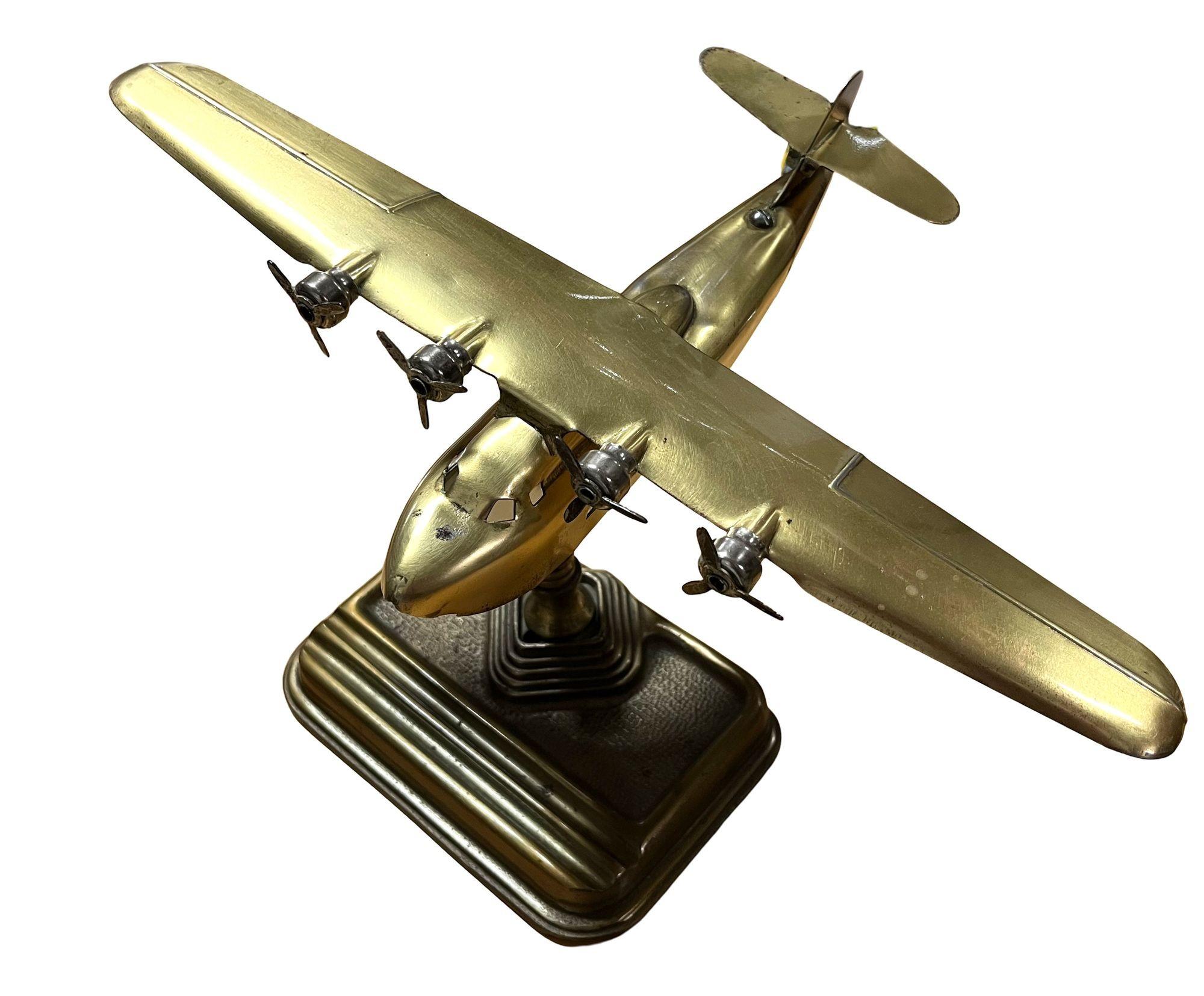 This vintage brass table lamp, crafted in the form of a four-propeller seaplane, exudes mid-century charm and aviation nostalgia. Made in Canada, it features fine detailing, including rotating propellers and a stepped Art Deco-style base. Both
