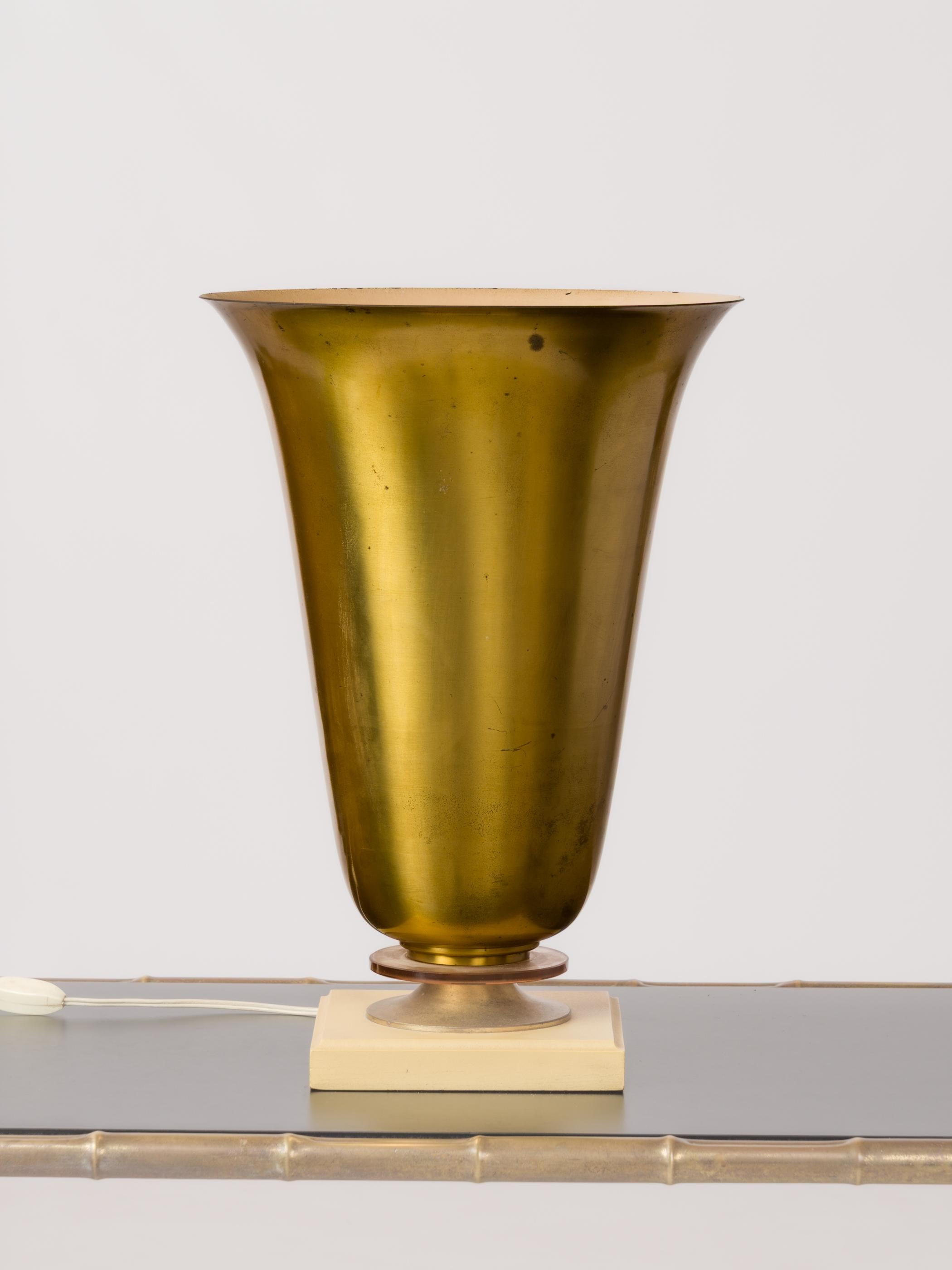 Lampada a forma di coppa in stile Art Déco, con coppa in ottone patinato e base in legno laccato giallo sormontata da un disco di vetro rosa pallido. Presa e cablaggio originali europei.
Questa lampada viene spedita dalla Francia e può essere