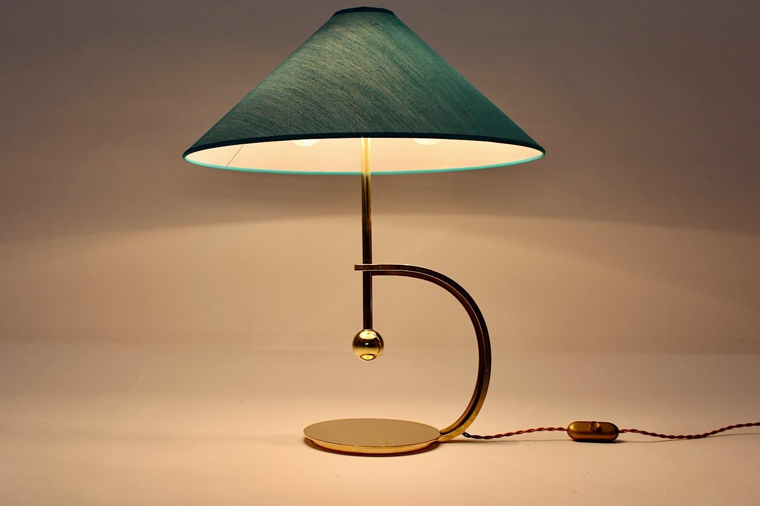 Art Deco vintage table lamp or desk lamp from solid brass circa 1925 Vienna.
While the brass is in wonderful condition, polished some times ago, the new handmade lamp shade in original shape shows a turquoise teal light blue color tone. 
Two E 27