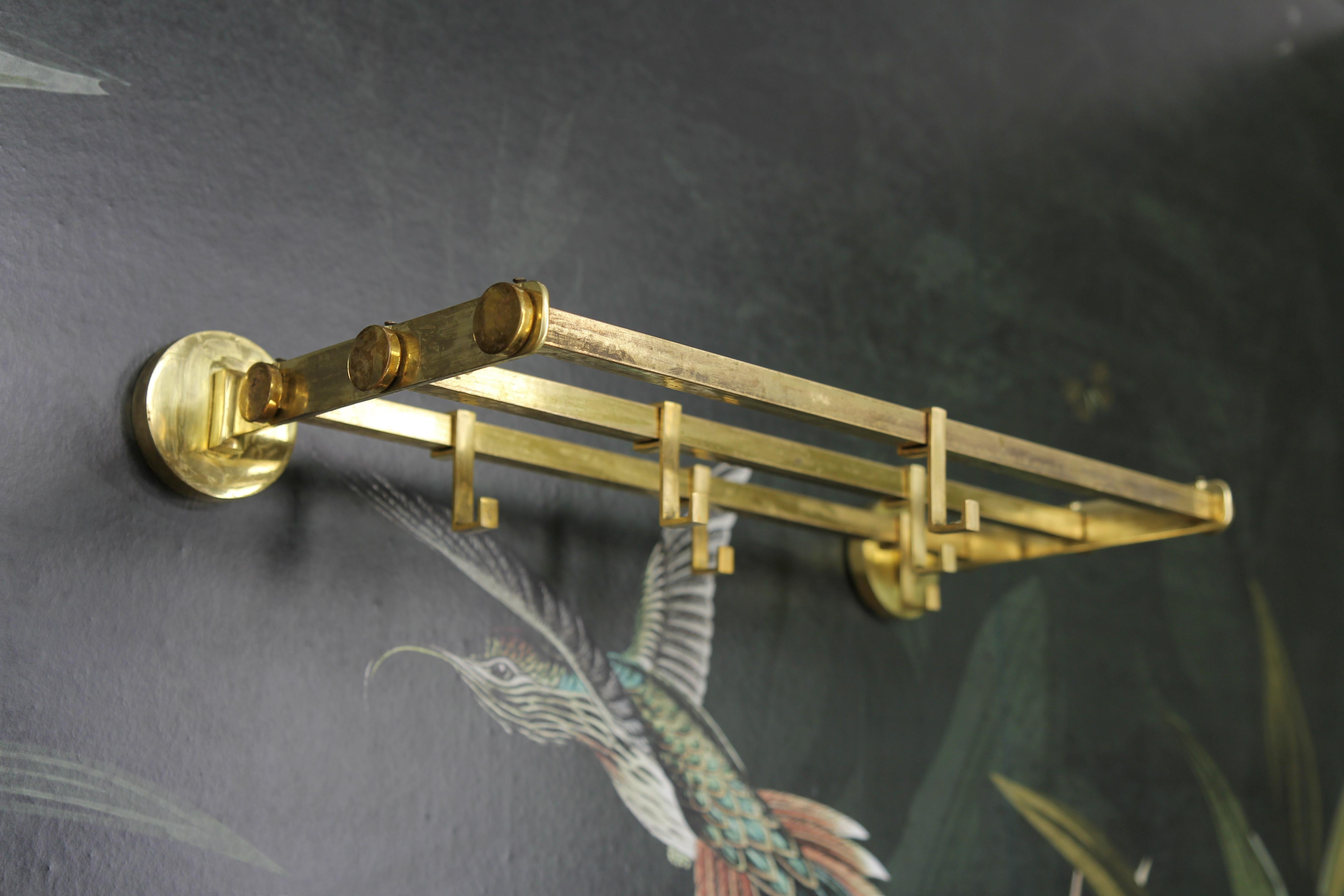 Art Deco brass wall coat rack, circa the 1930s, Germany.
An elegant Art Deco wall coat rack made of brass with six sliding hooks.
Dimensions: height: 8 cm / 3.15 in; width: 56 cm / 22.04 in; depth: 23 cm / 9.05 in.
In good condition with some signs